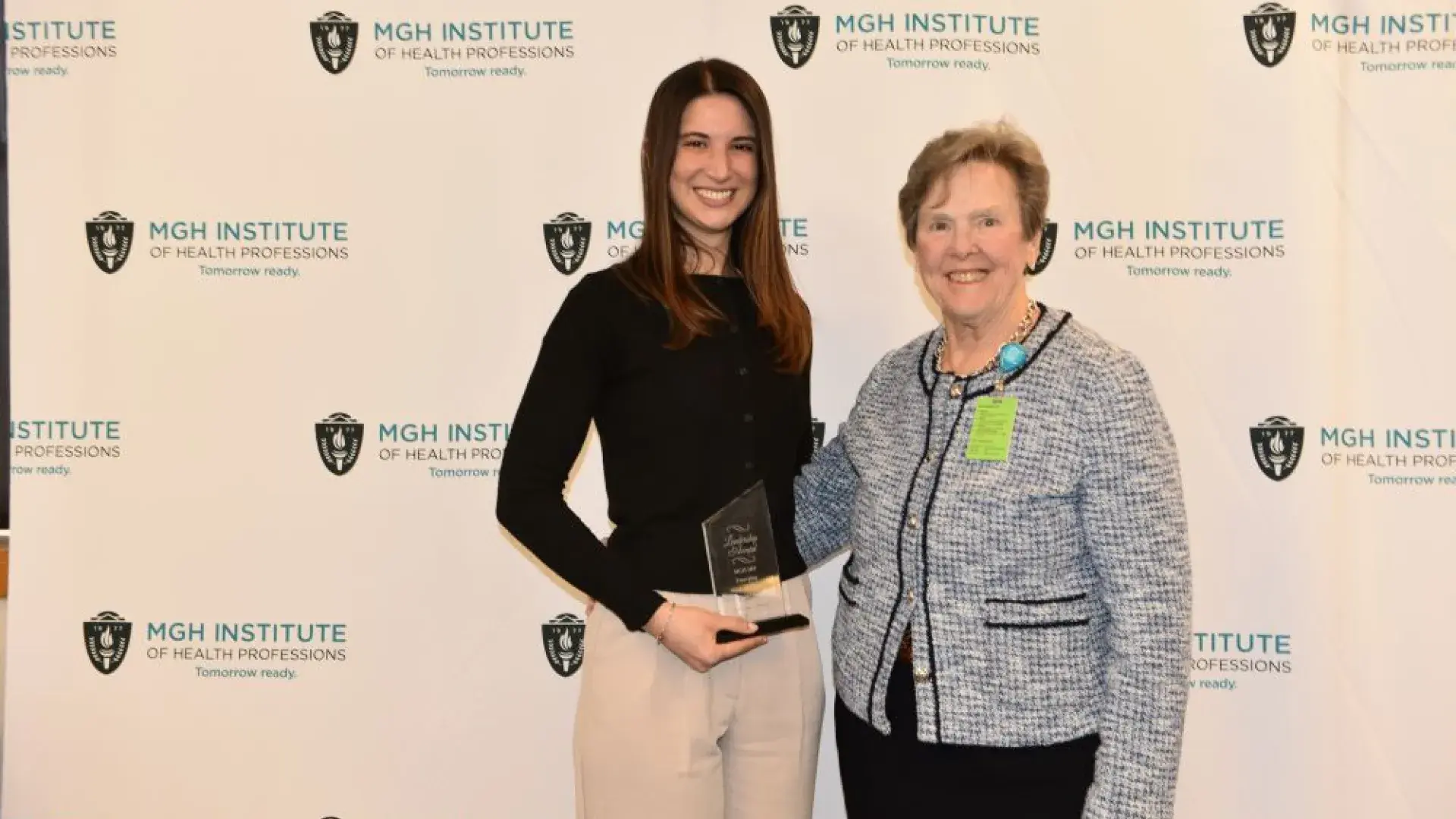 Two women posting with award