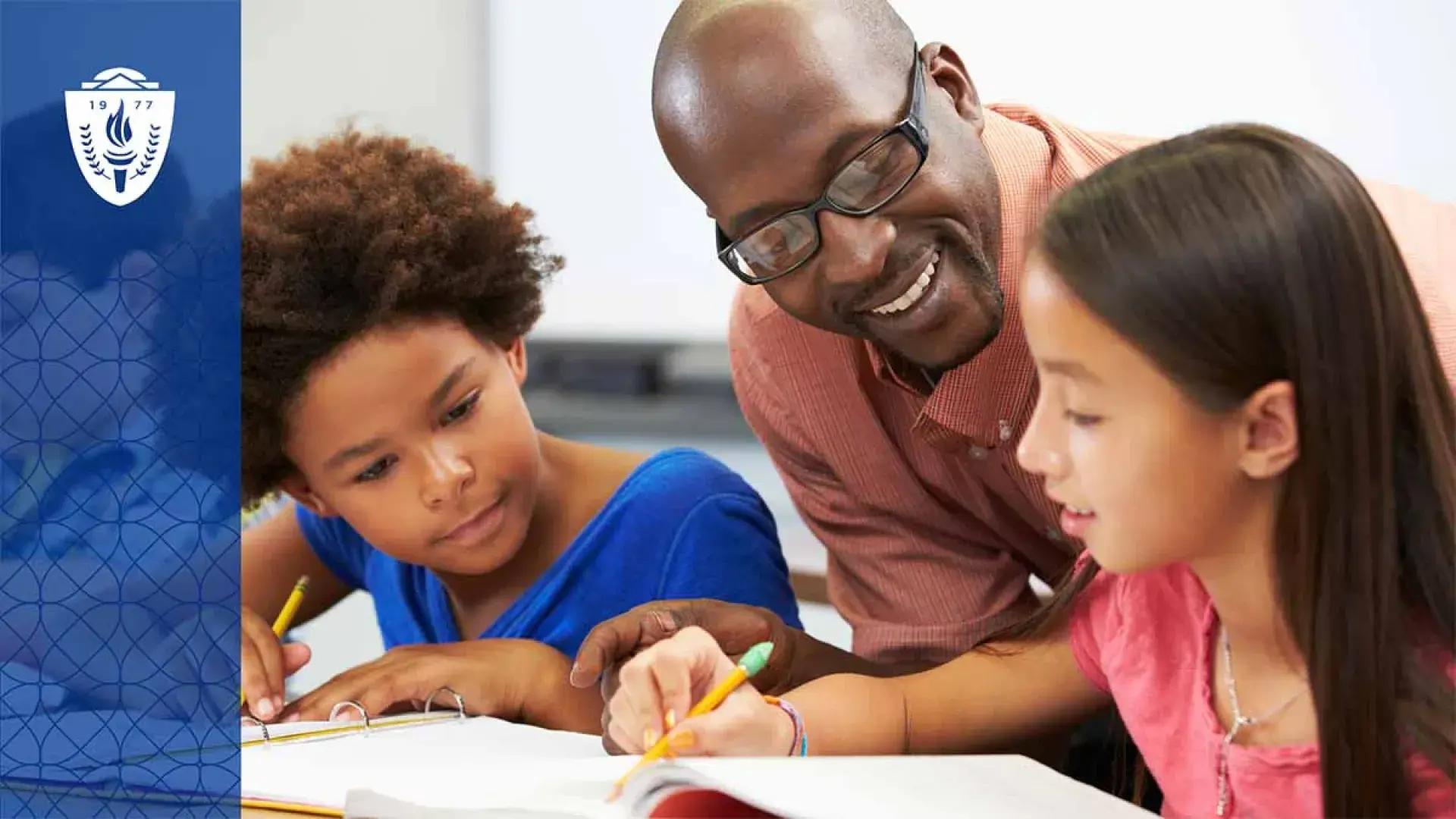 Teacher helping two students with schoolwork at a desk 