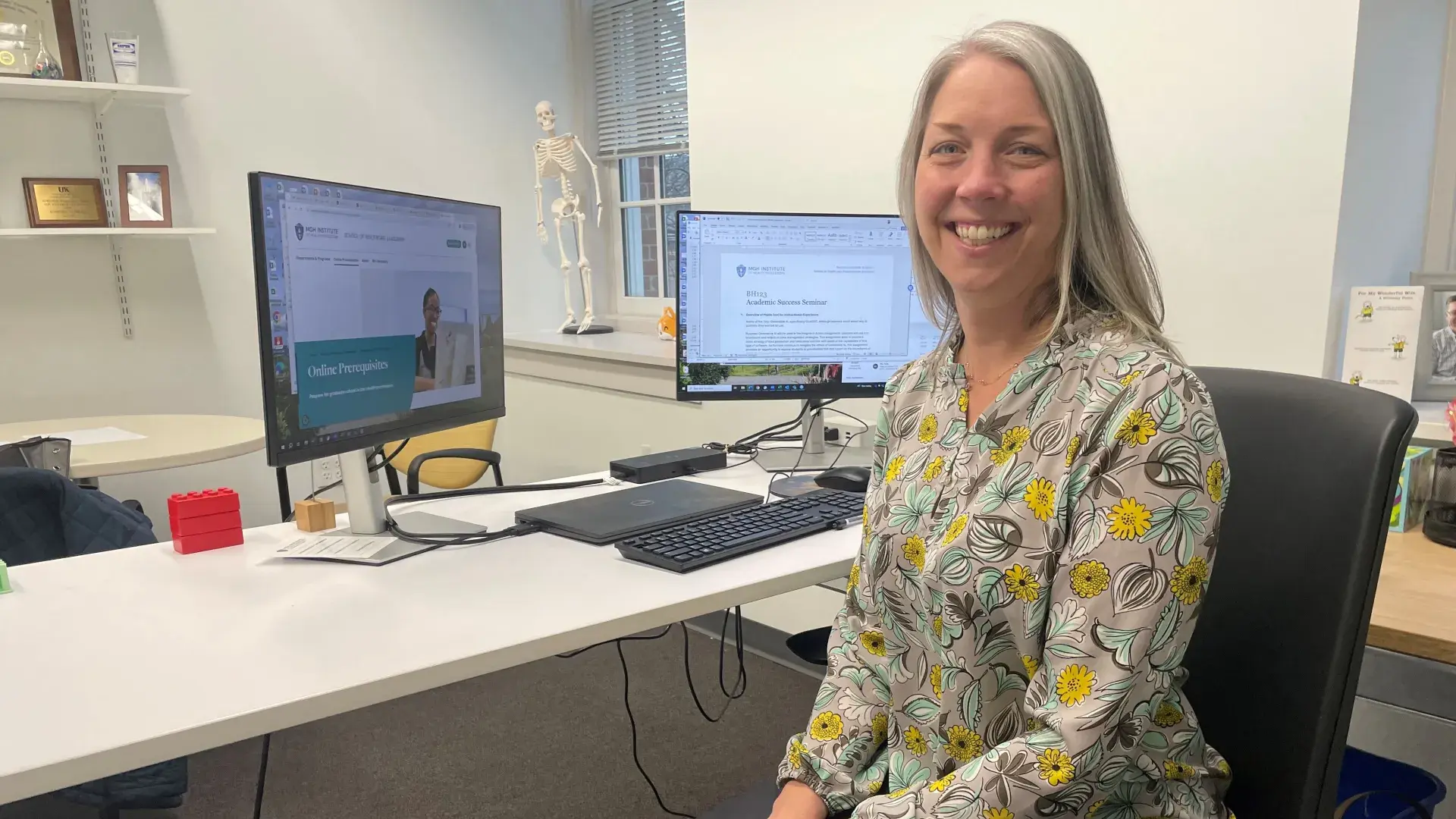 Woman sitting at desk smiling at camera 