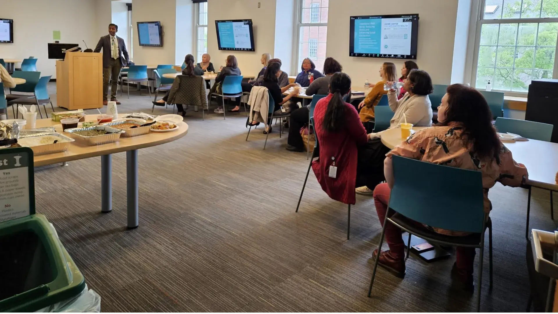 man speaking to room full of people
