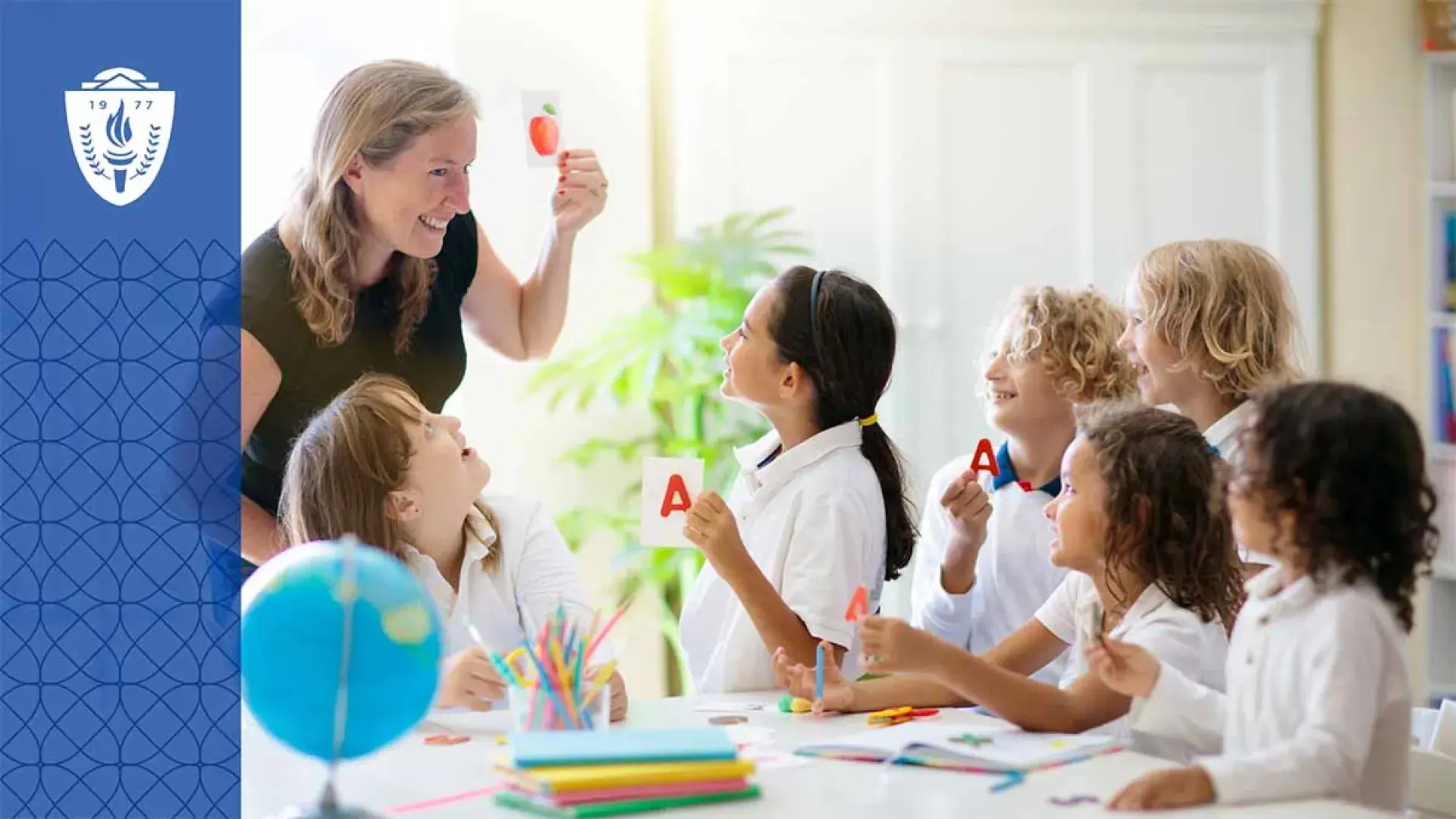 Teacher smiling and holding a drawing of an apple in front of four kids