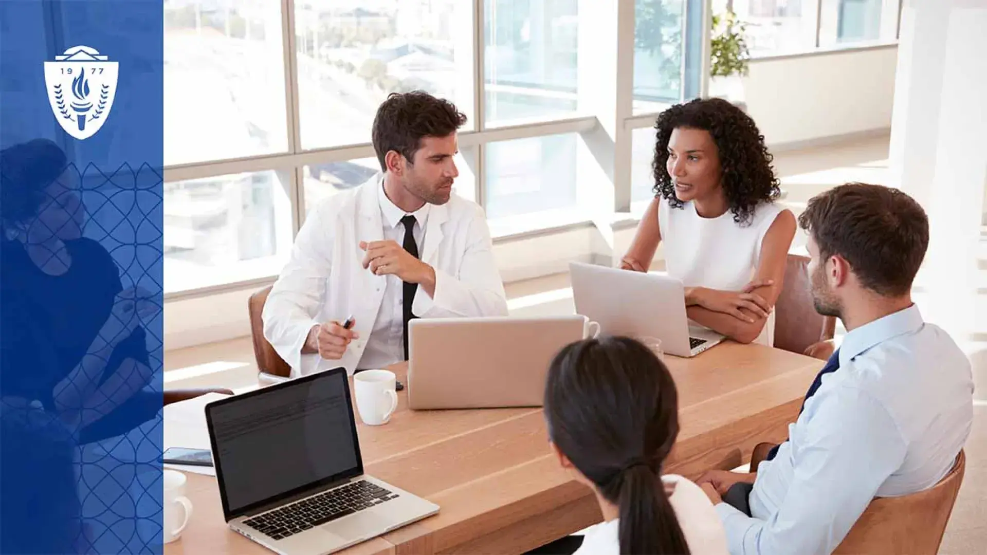 4 people sitting at table with laptops