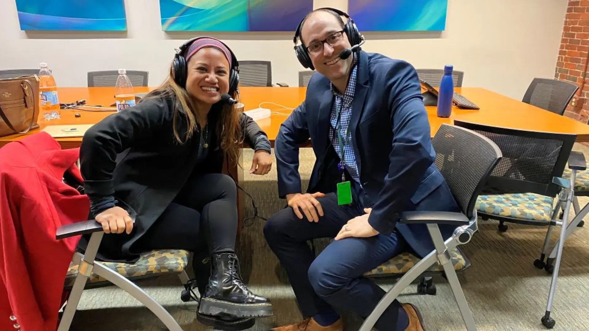 Two people wearing headsets sitting at a table