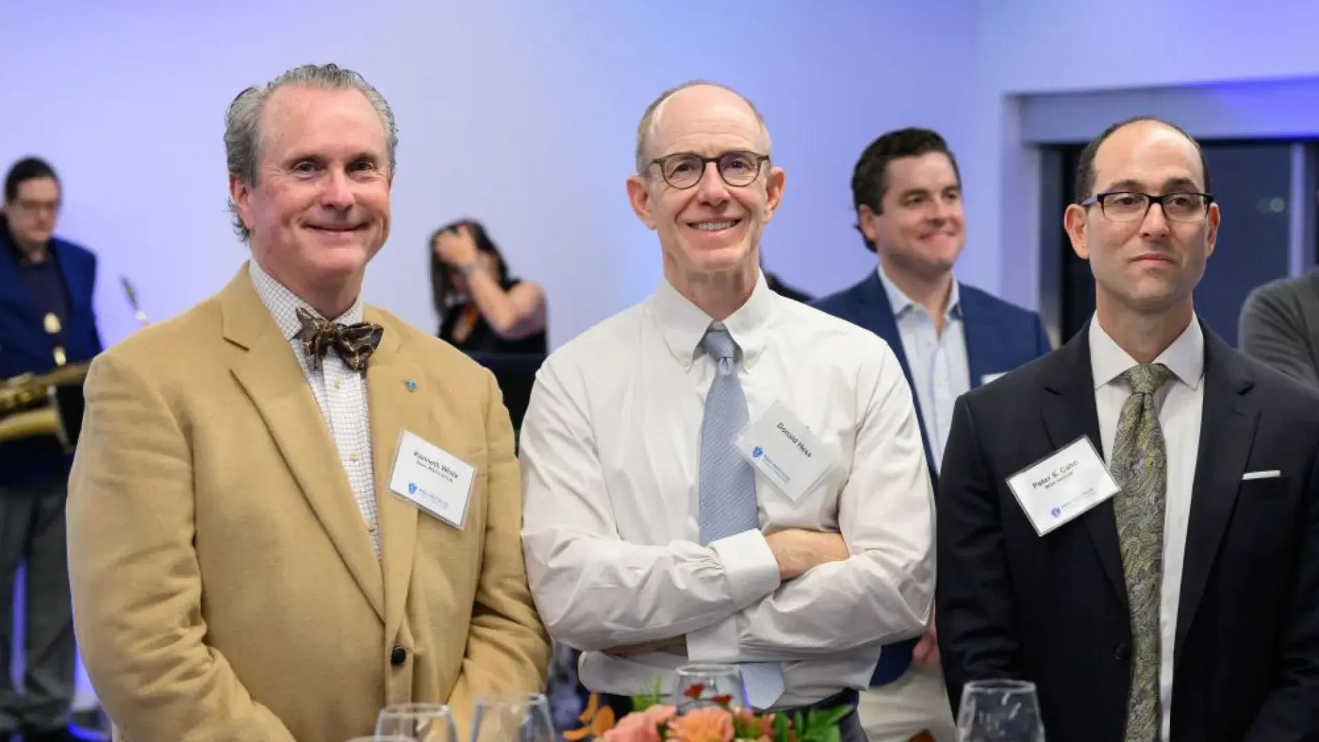 Three men stand at an event