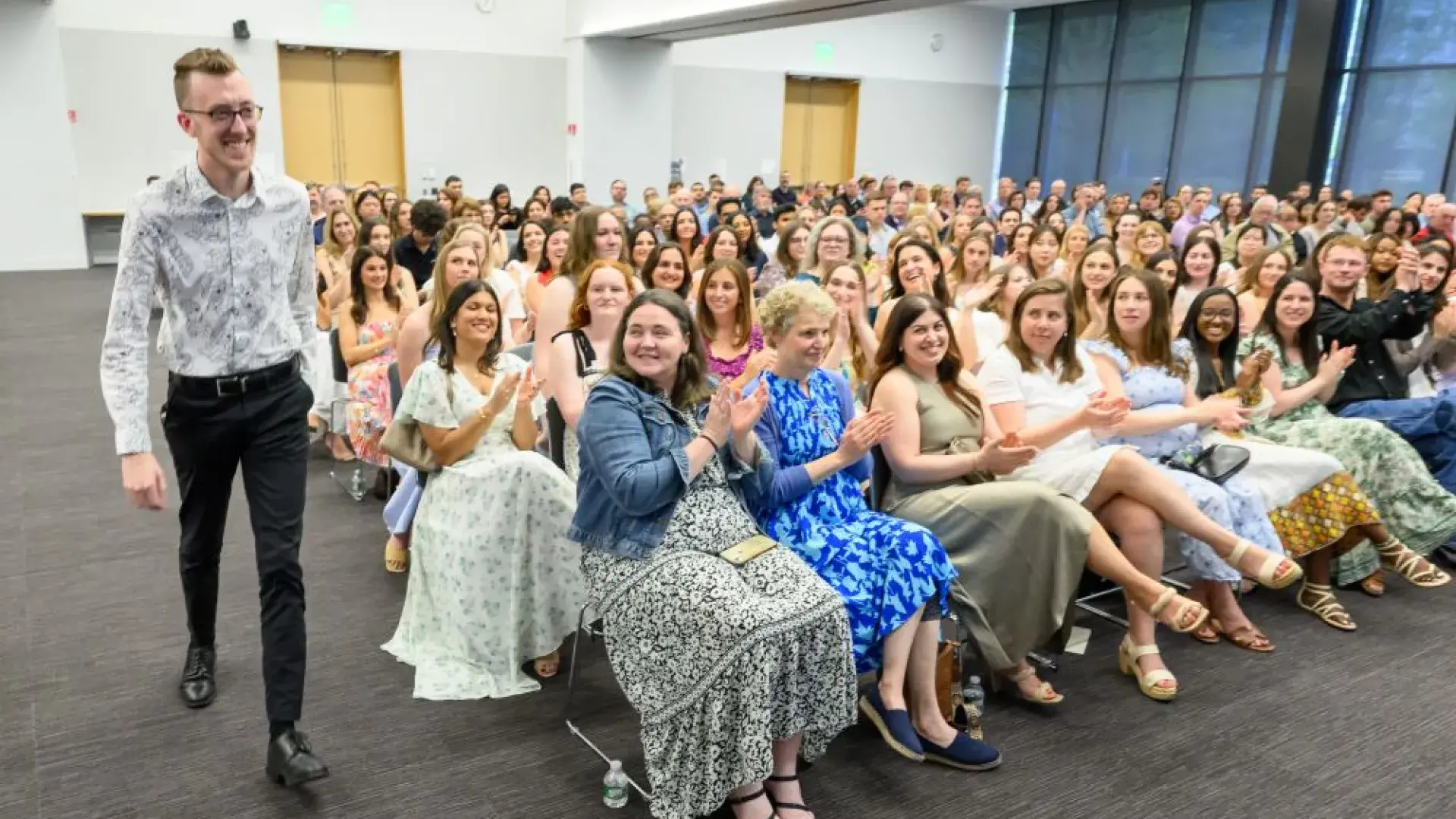 A man walks forward while people in the audience clap