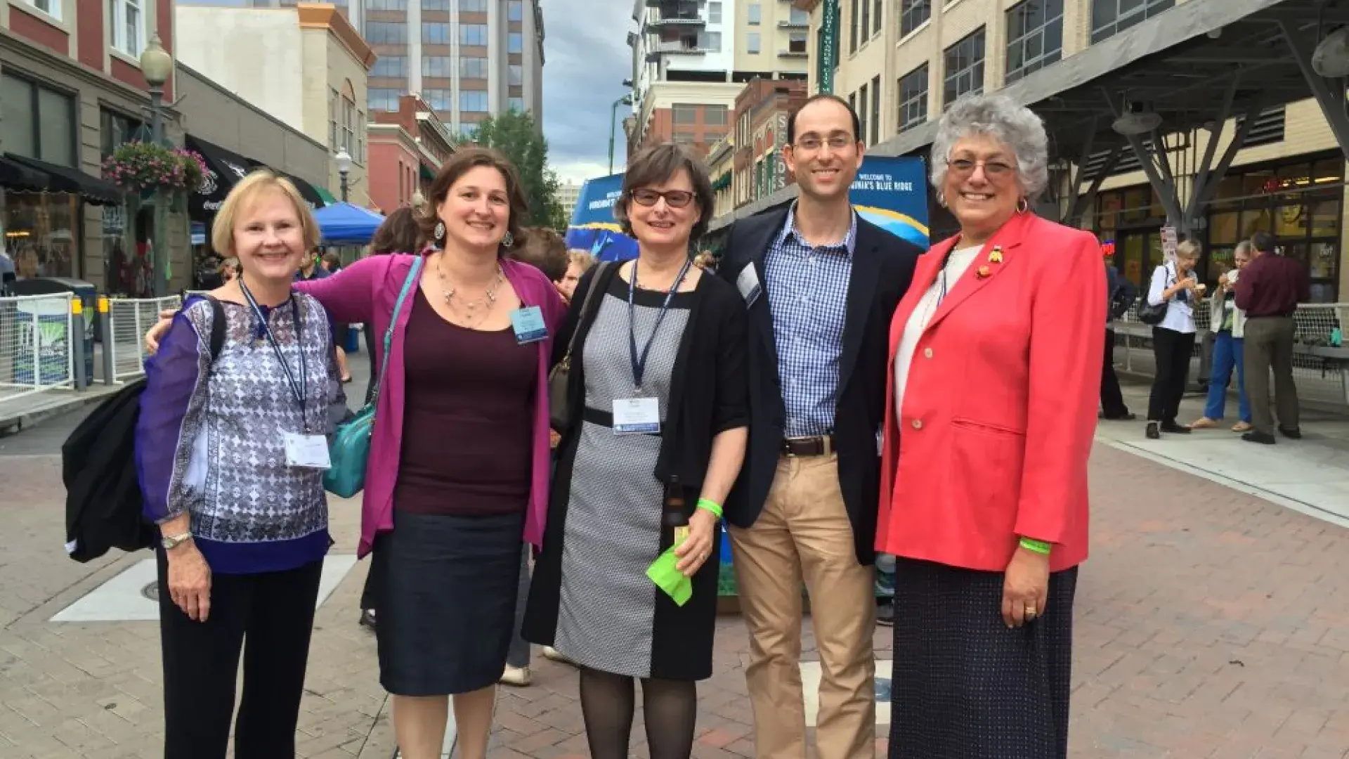 Five people pose for the camera outside 