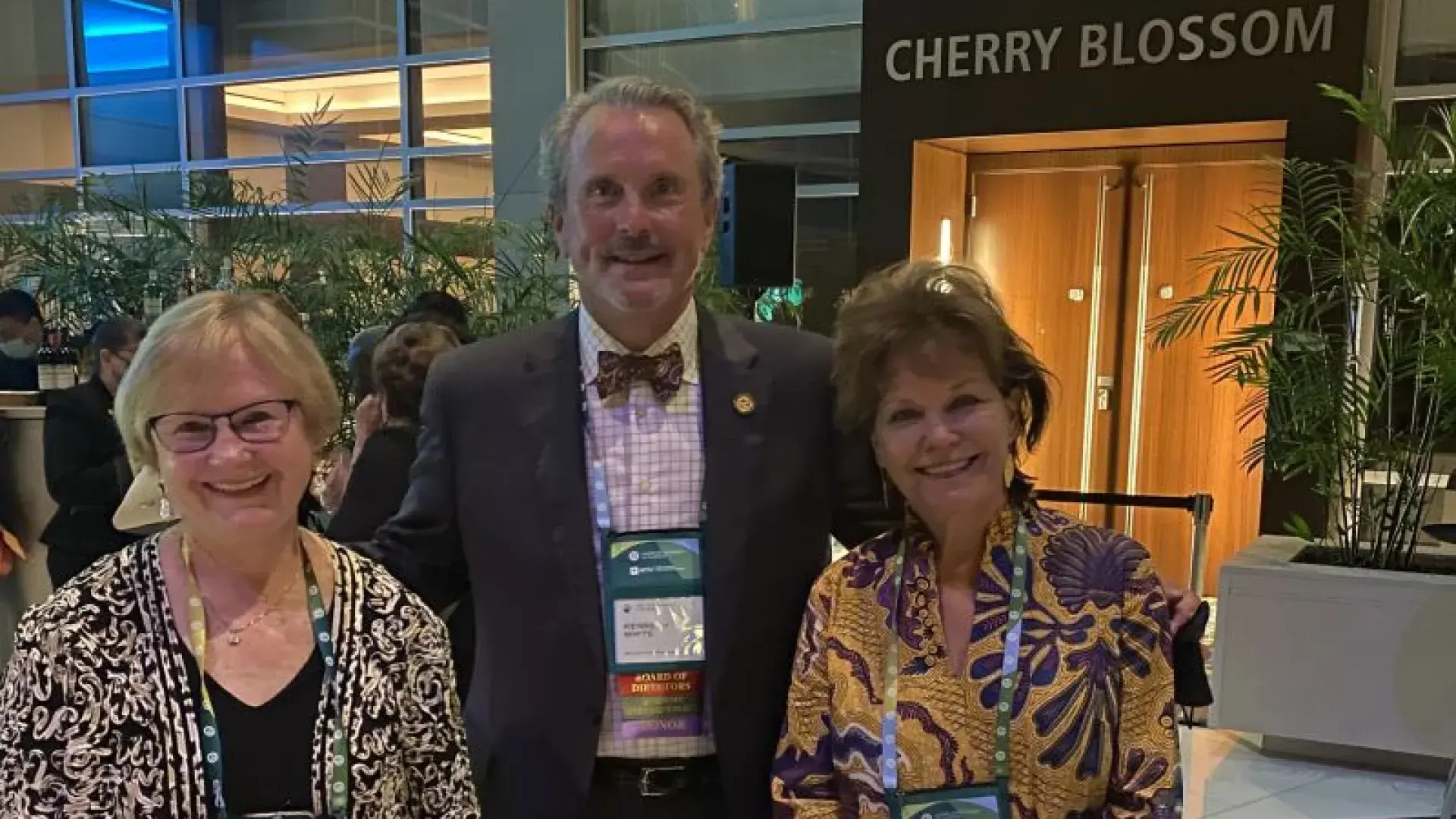 Three people stand behind a table 