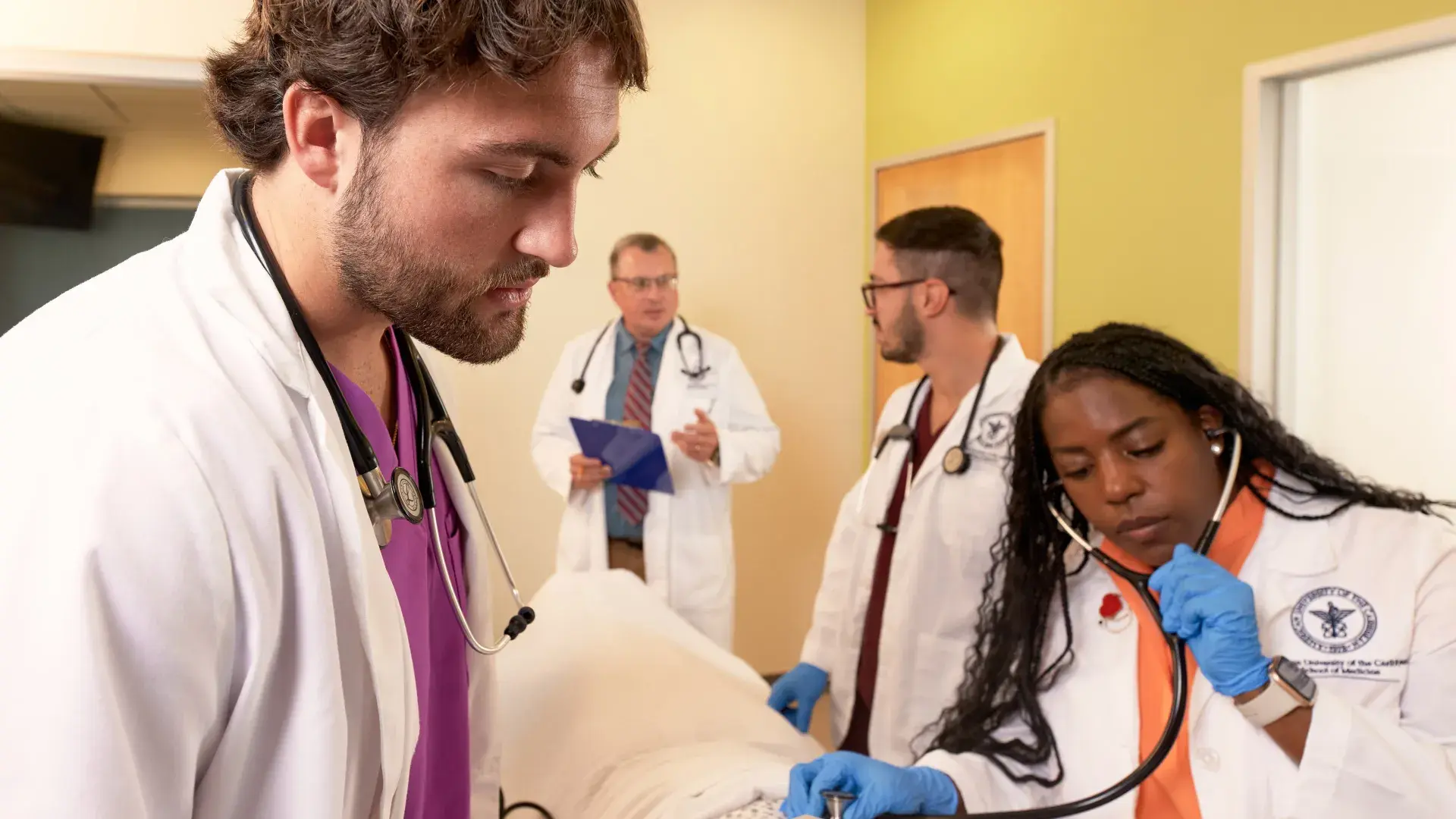 a woman uses a stethoscope on a manikin
