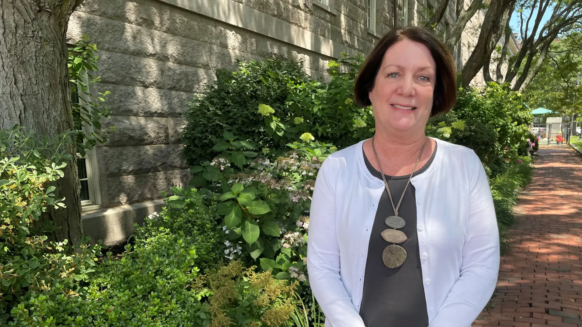Woman standing in front of bushes 