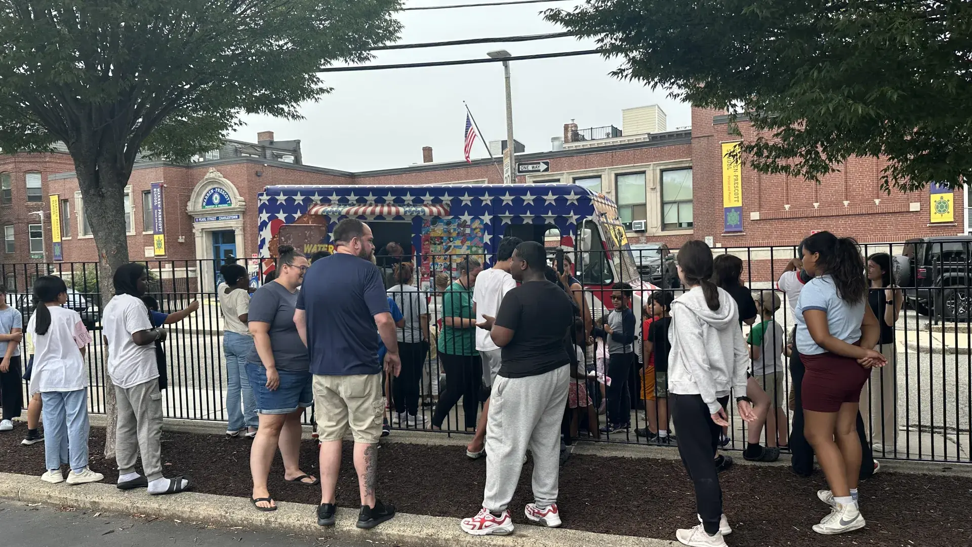 Children and adults lining up at an ice cream truck
