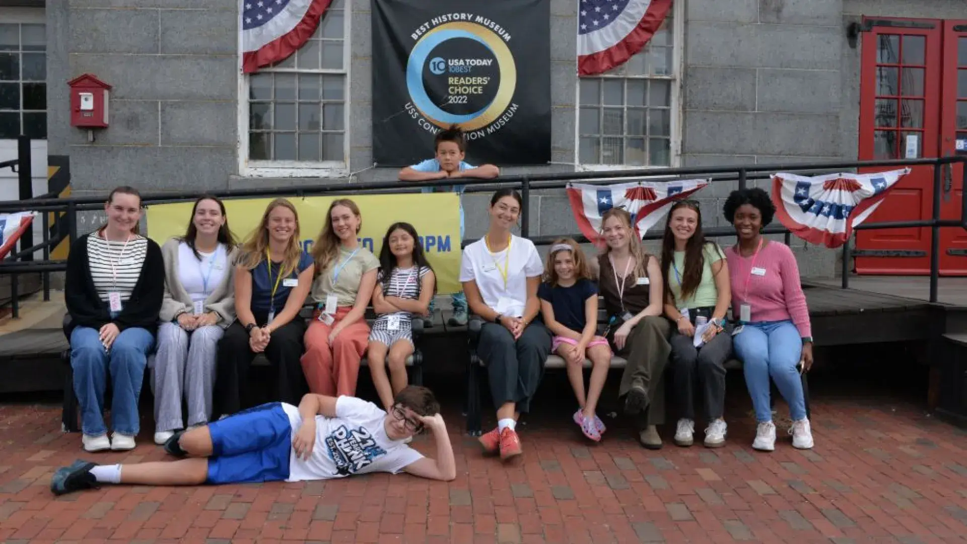 Group of people posing on a bend in from of a brick building 