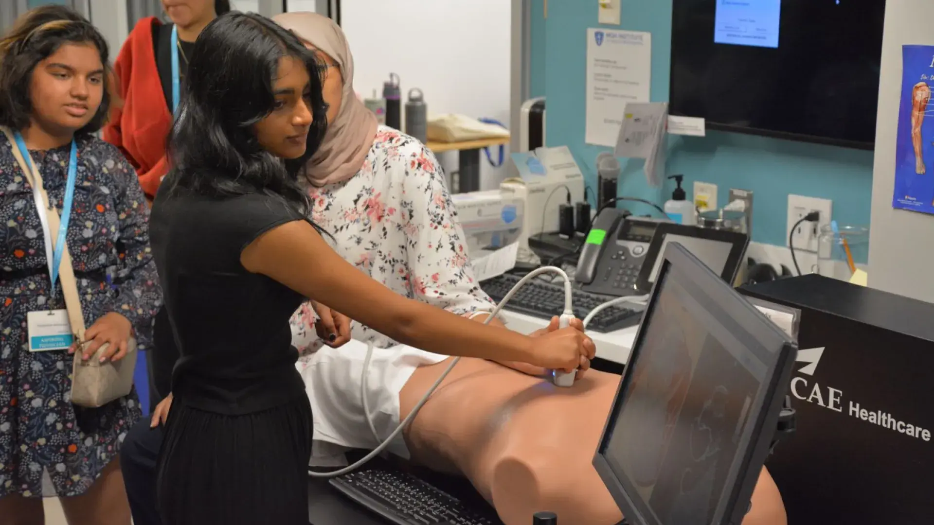 A person uses an ultrasound machine on a manikin