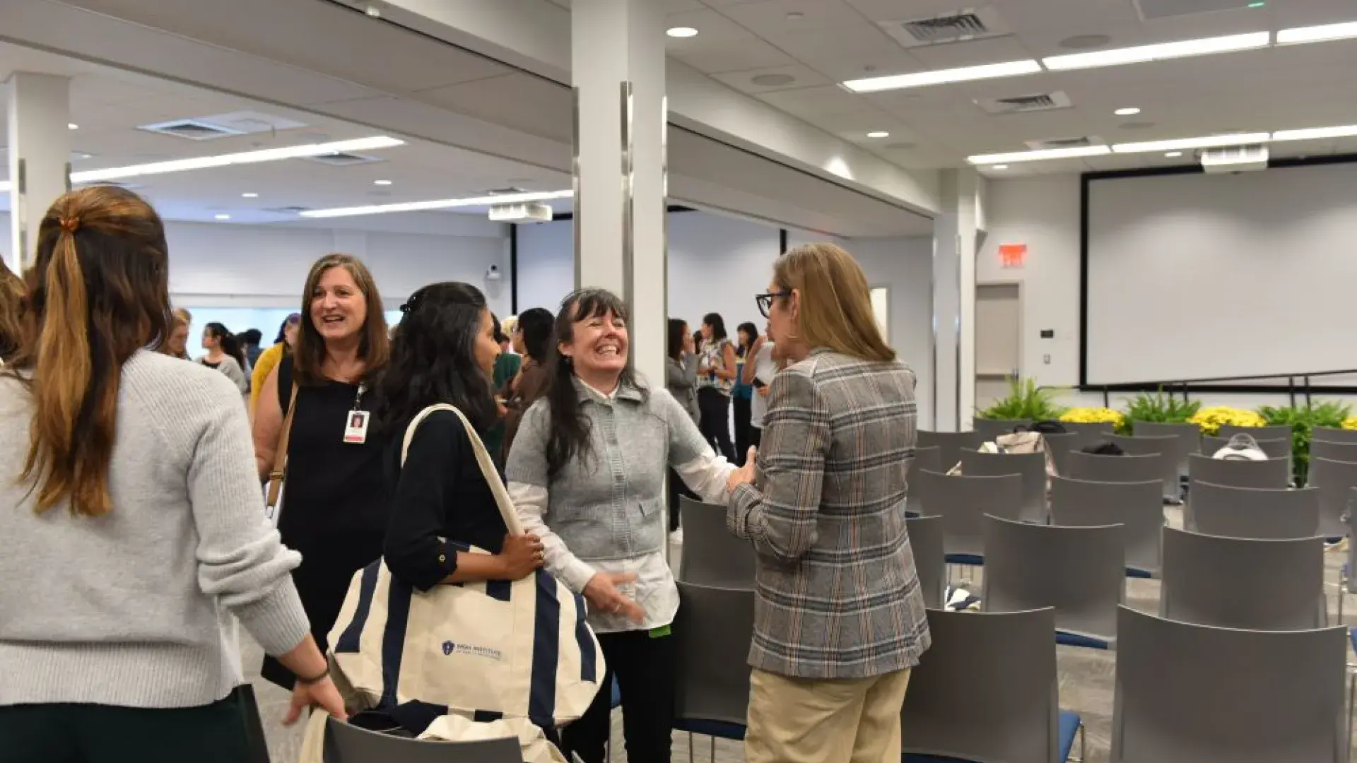 group of women laughing in a conference room