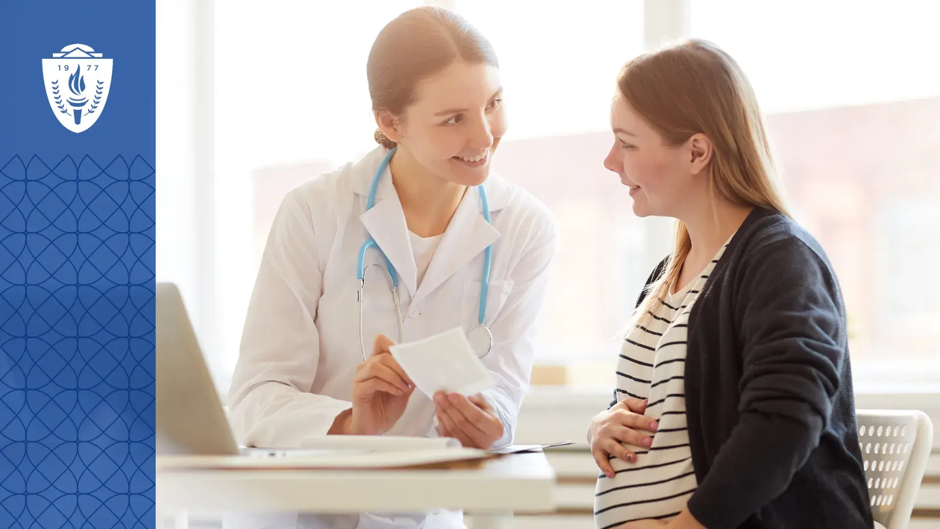 Woman wearing white lab coat and stethoscope review a document with a patient