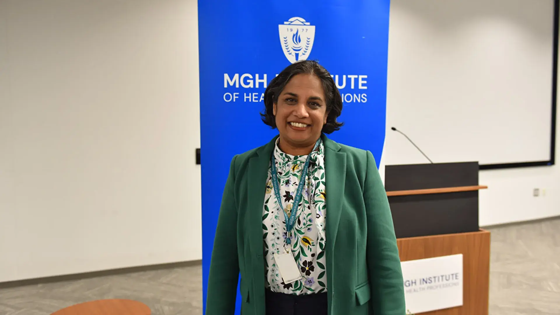 A woman stands in front of a blue banner