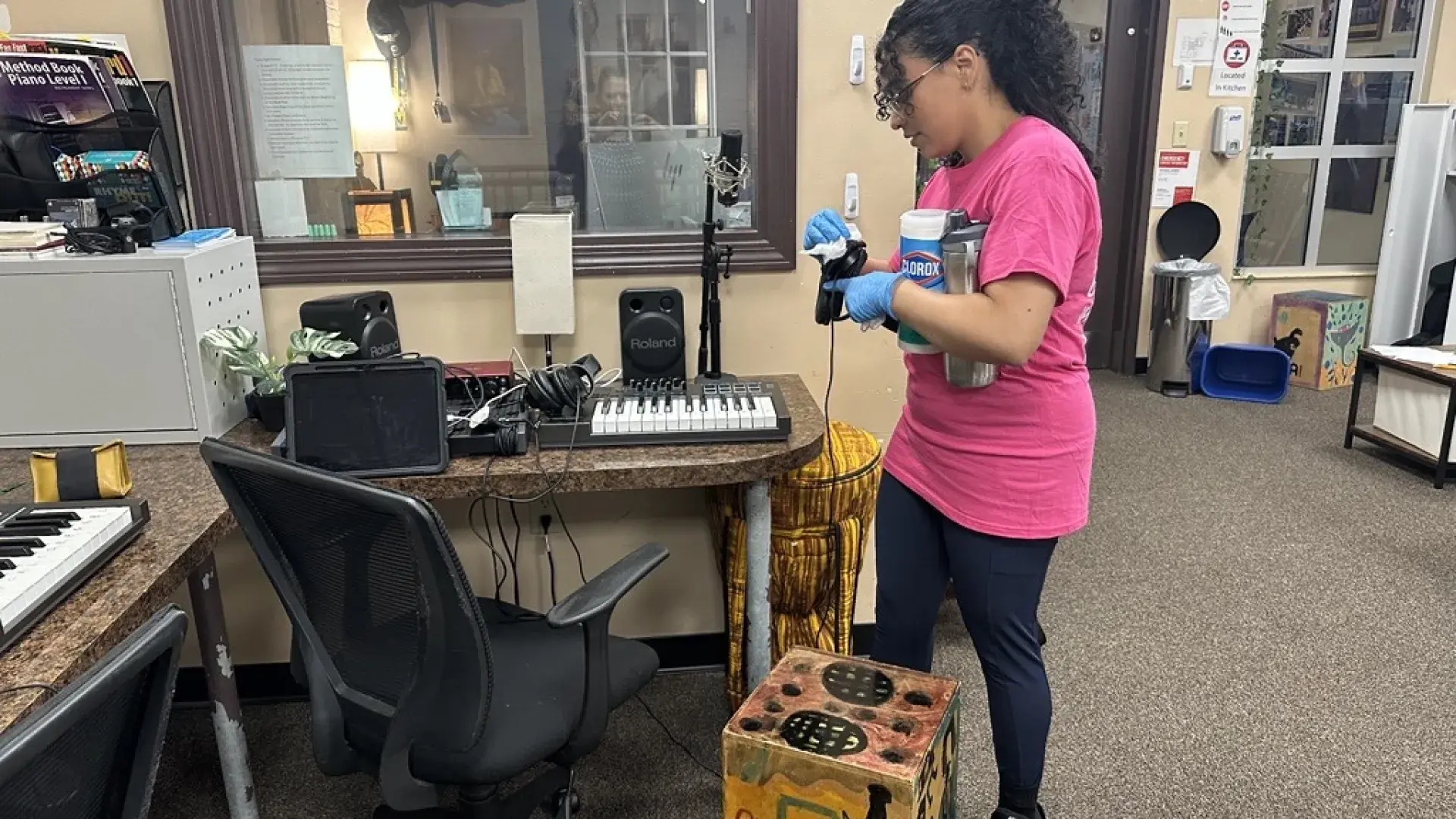 A woman cleans headphones attached to a keyboard