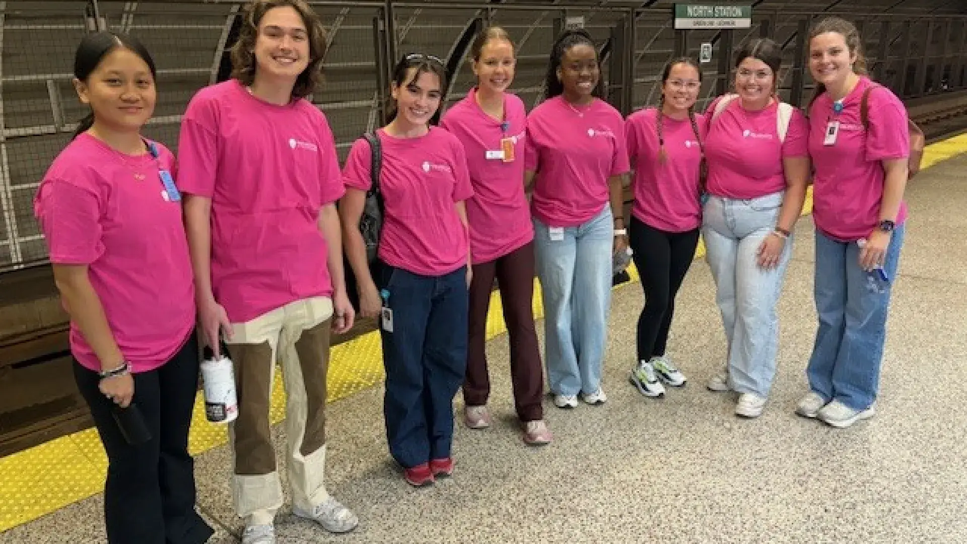 A group of women poses while standing in a row