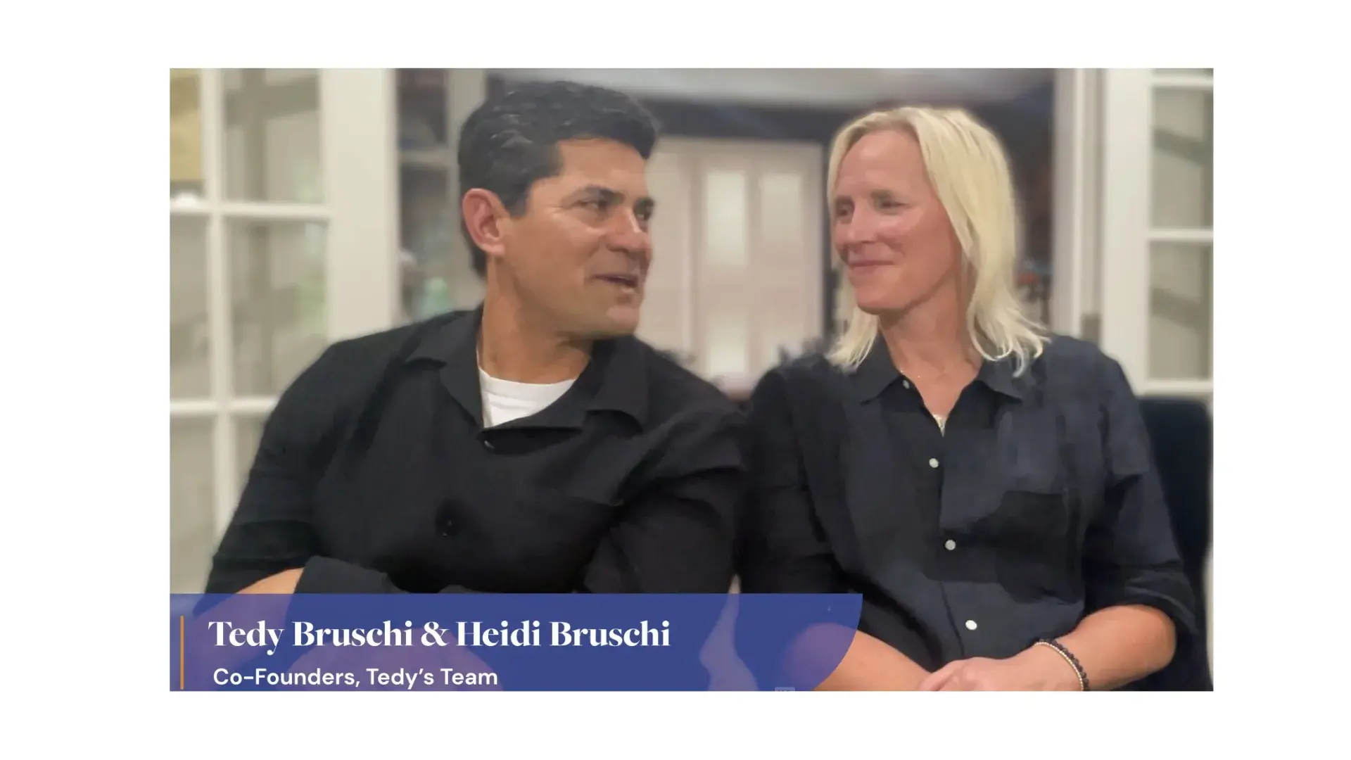man and woman in black shirts look lovingly at each other
