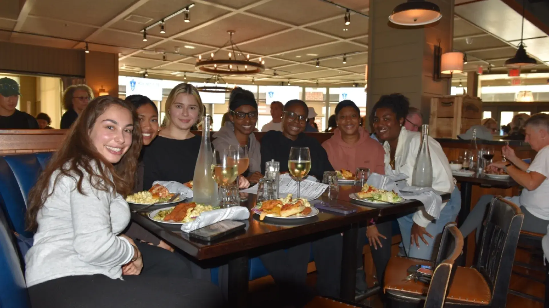Seven women sit around a table at a restaurant