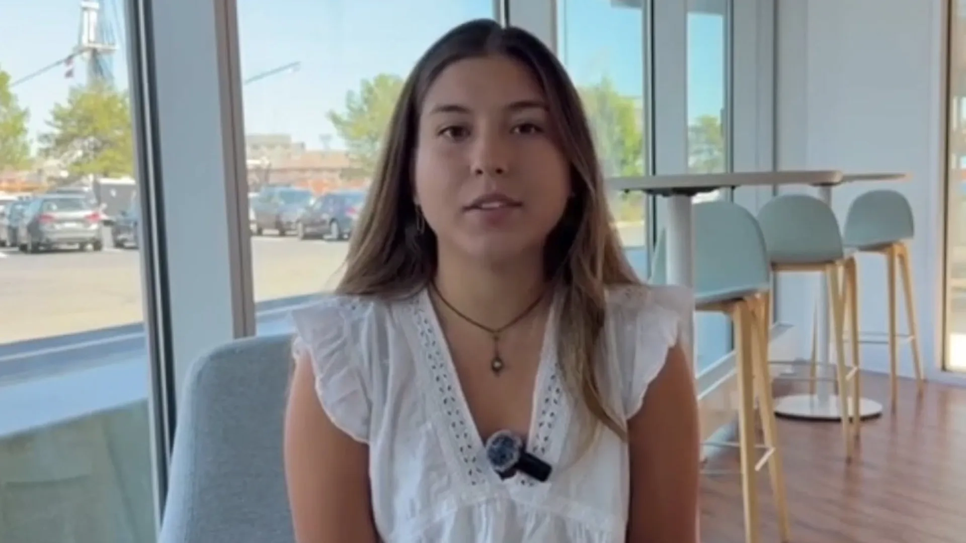 woman speaks in front of a window