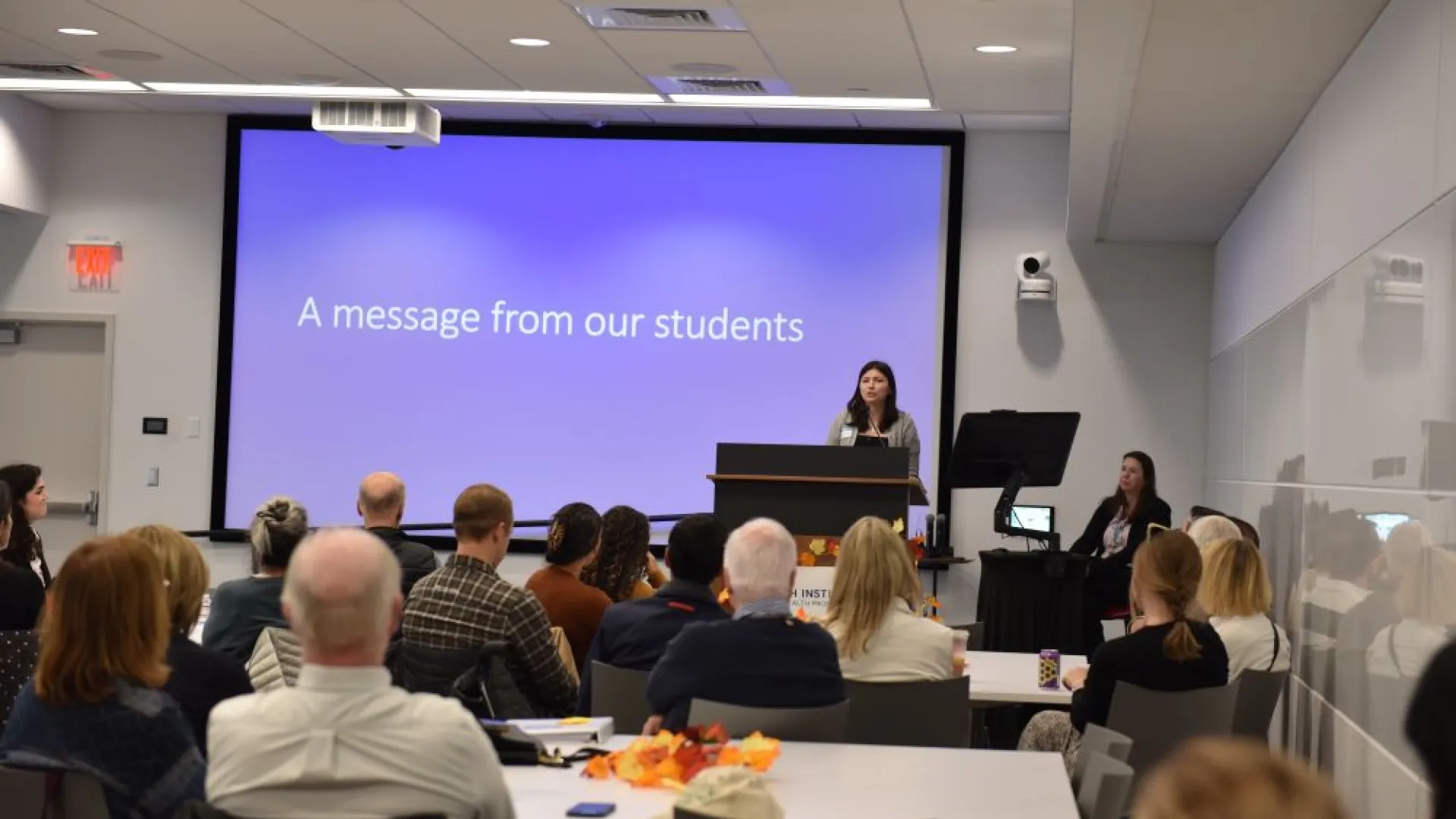 A women speaks to an audience from a podium 