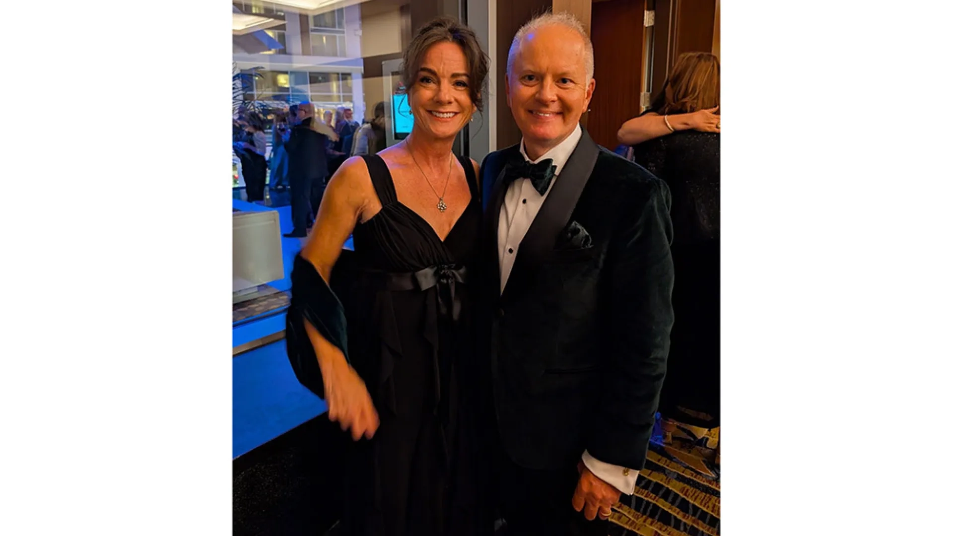 A man and woman stand next to each other and pose for camera