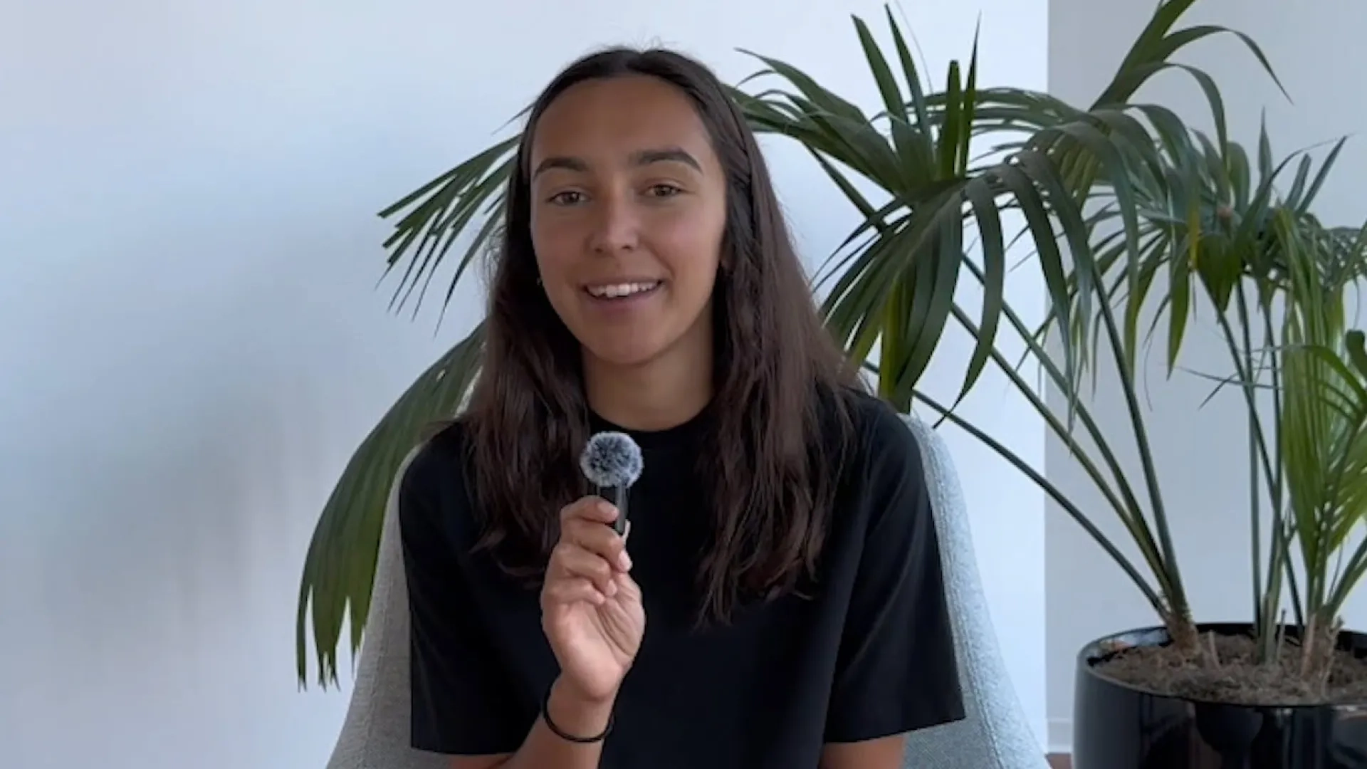 woman holds tiny fuzzy microphone
