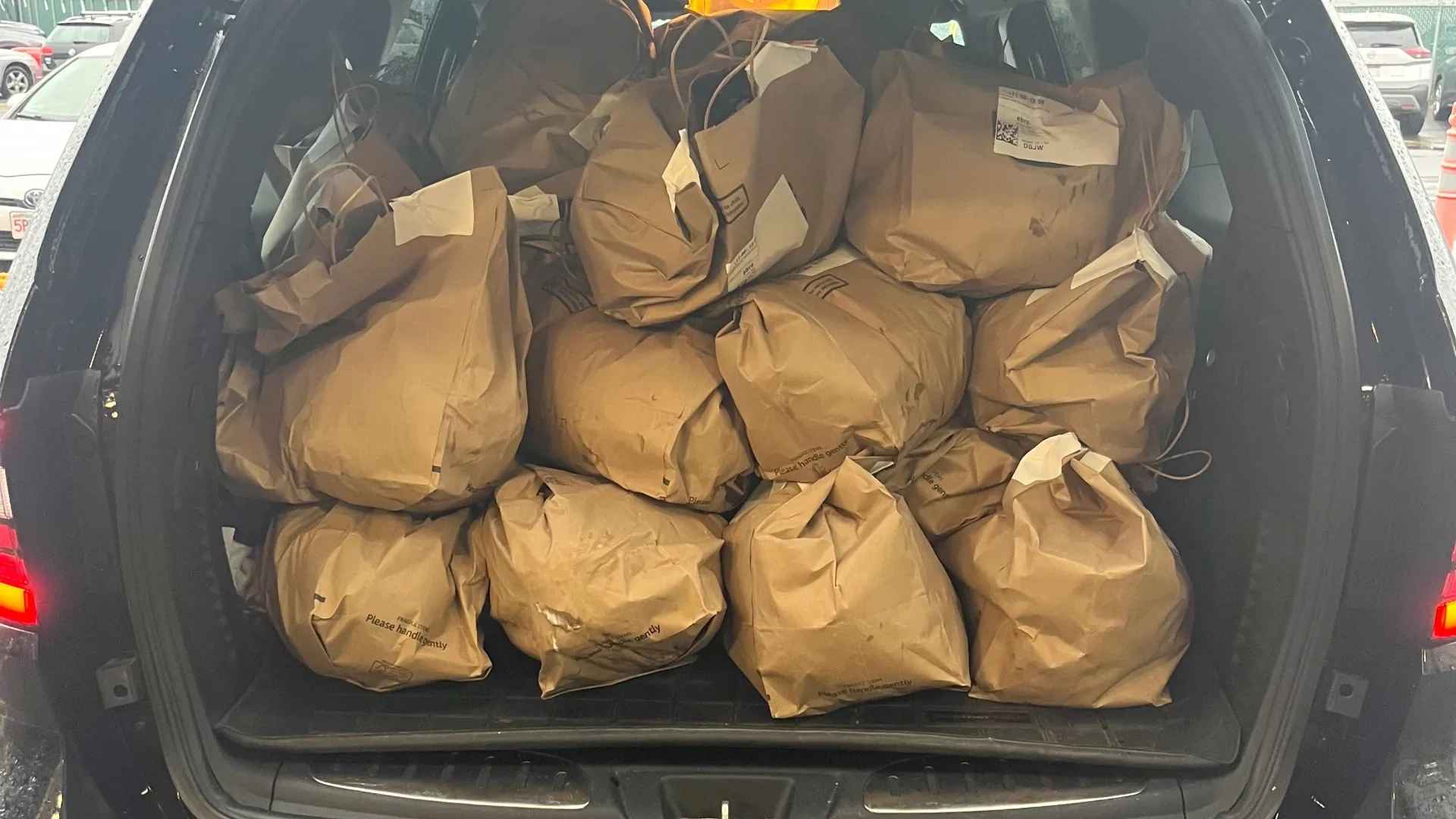 The back of a car with the hatchback open filled with bags