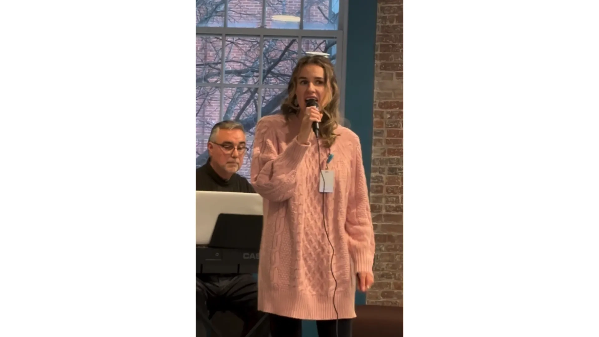 woman singing in pink sweater