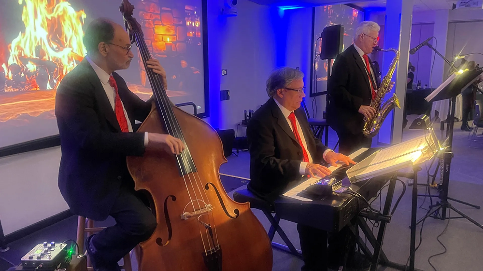 Saxophone, keyboard, and upright bass players perform