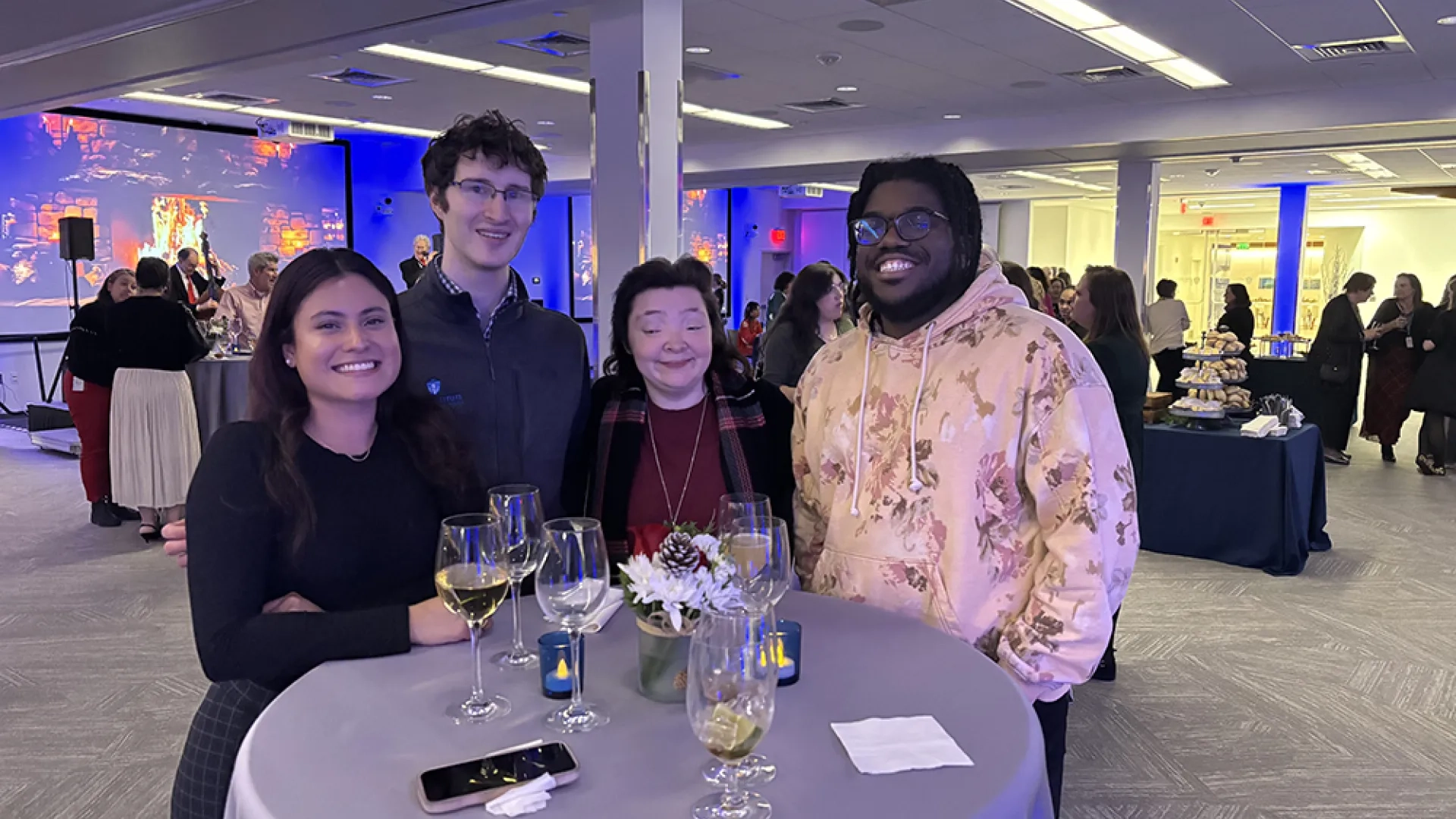 Four people pose for a photo at a party