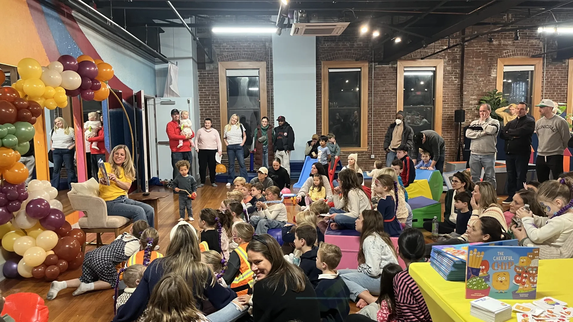 Woman reads book in front of crowd