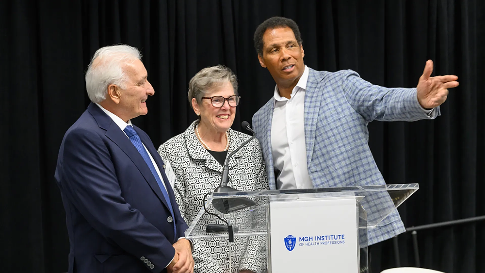 Three people stand behind a podium