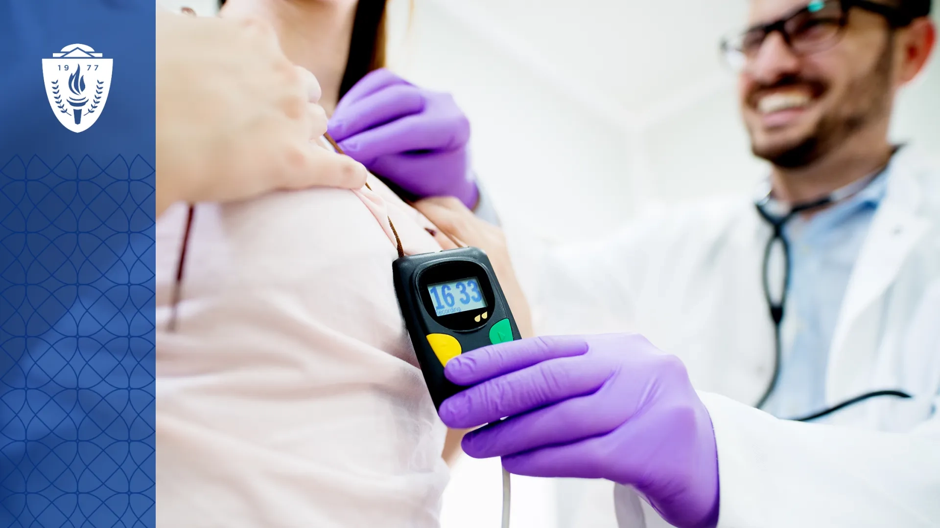 Doctor wearing lab coat and purple gloves holding a small rectangular medical device up to patient.