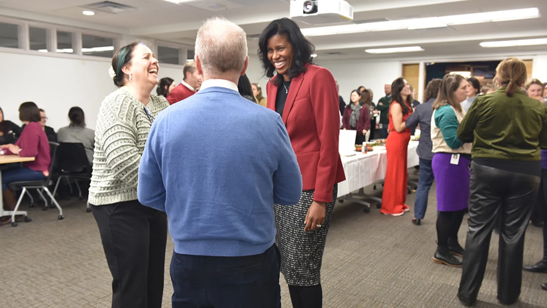 Three people talk at a party