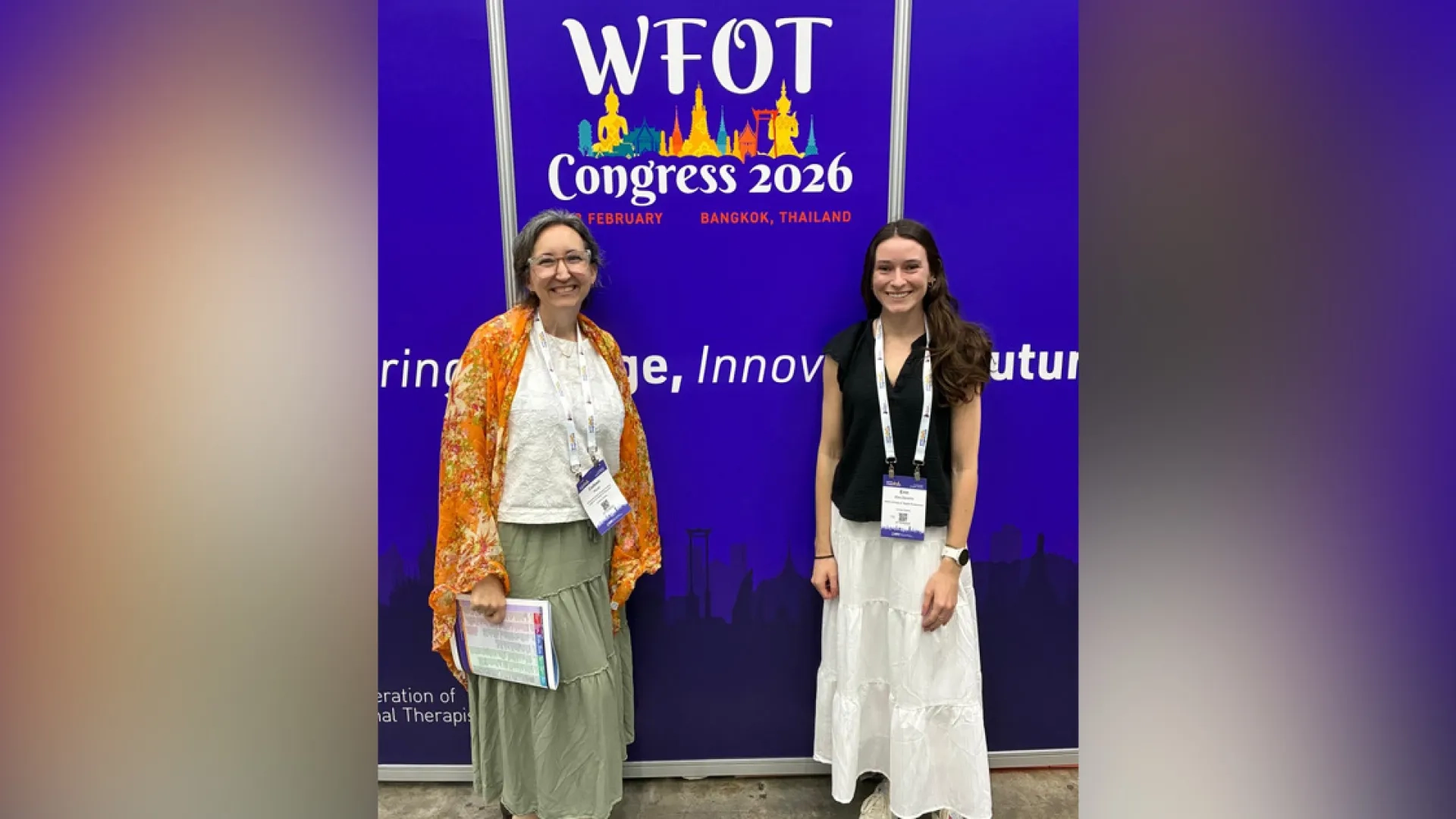 Two women standing in front of a backdrop with WFOT Congress 2026 Printed on it