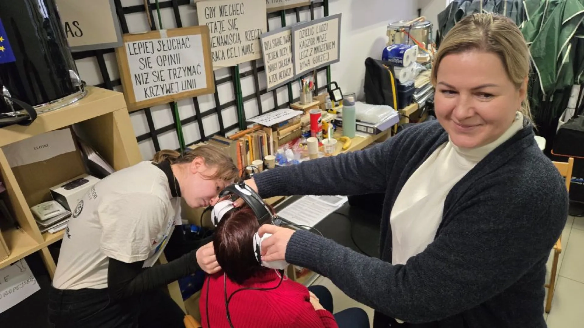 two women fitting a patient with a hearing aid
