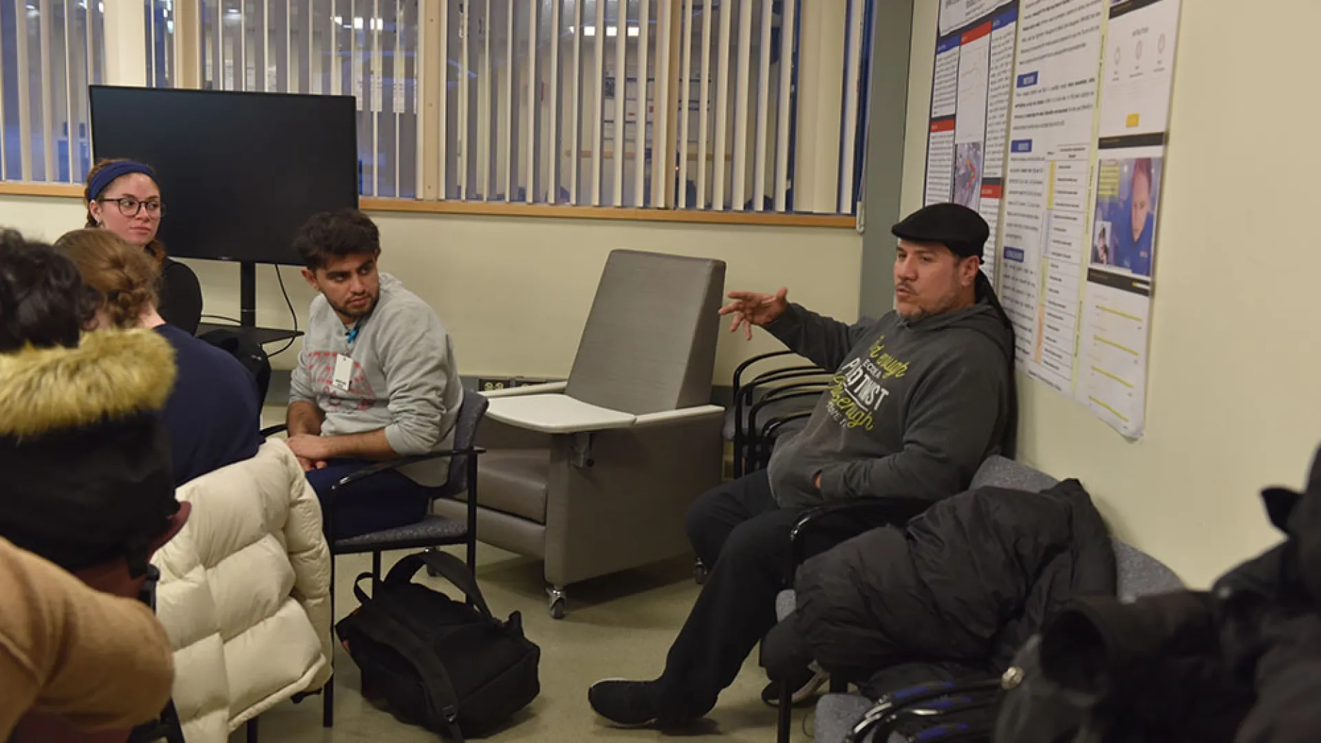 A man talks to people sitting at a table