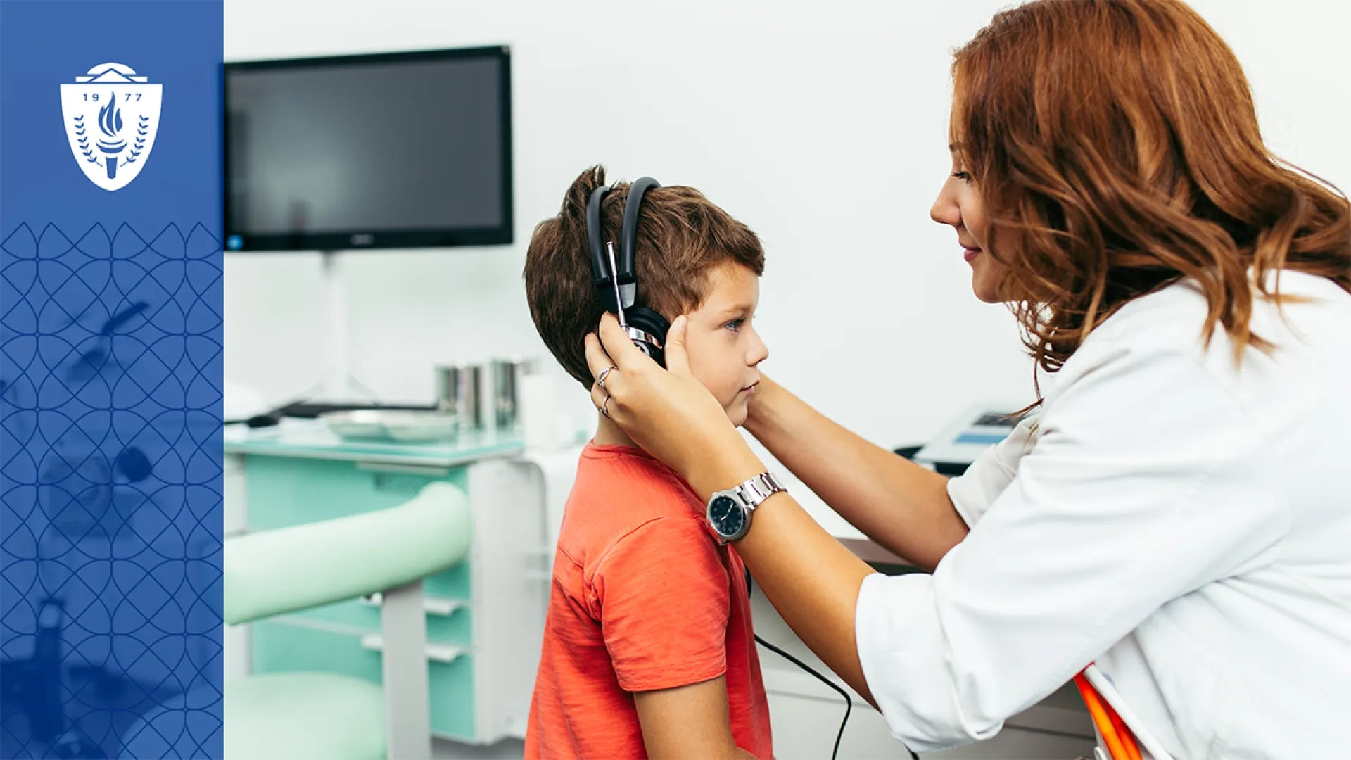 Woman wearing a lab coat putting headphone on a young boy wearing an orange T-shirt
