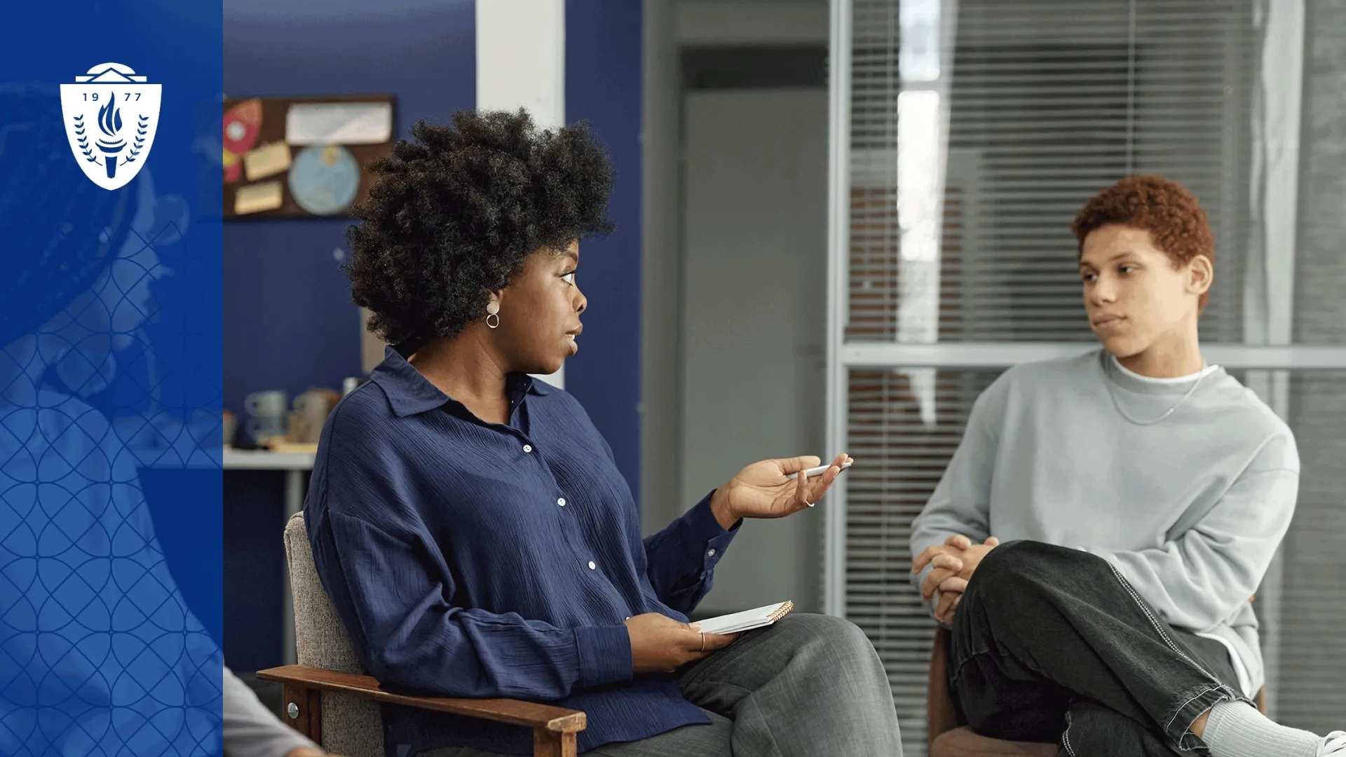 Two people sitting in charis next to each other in office