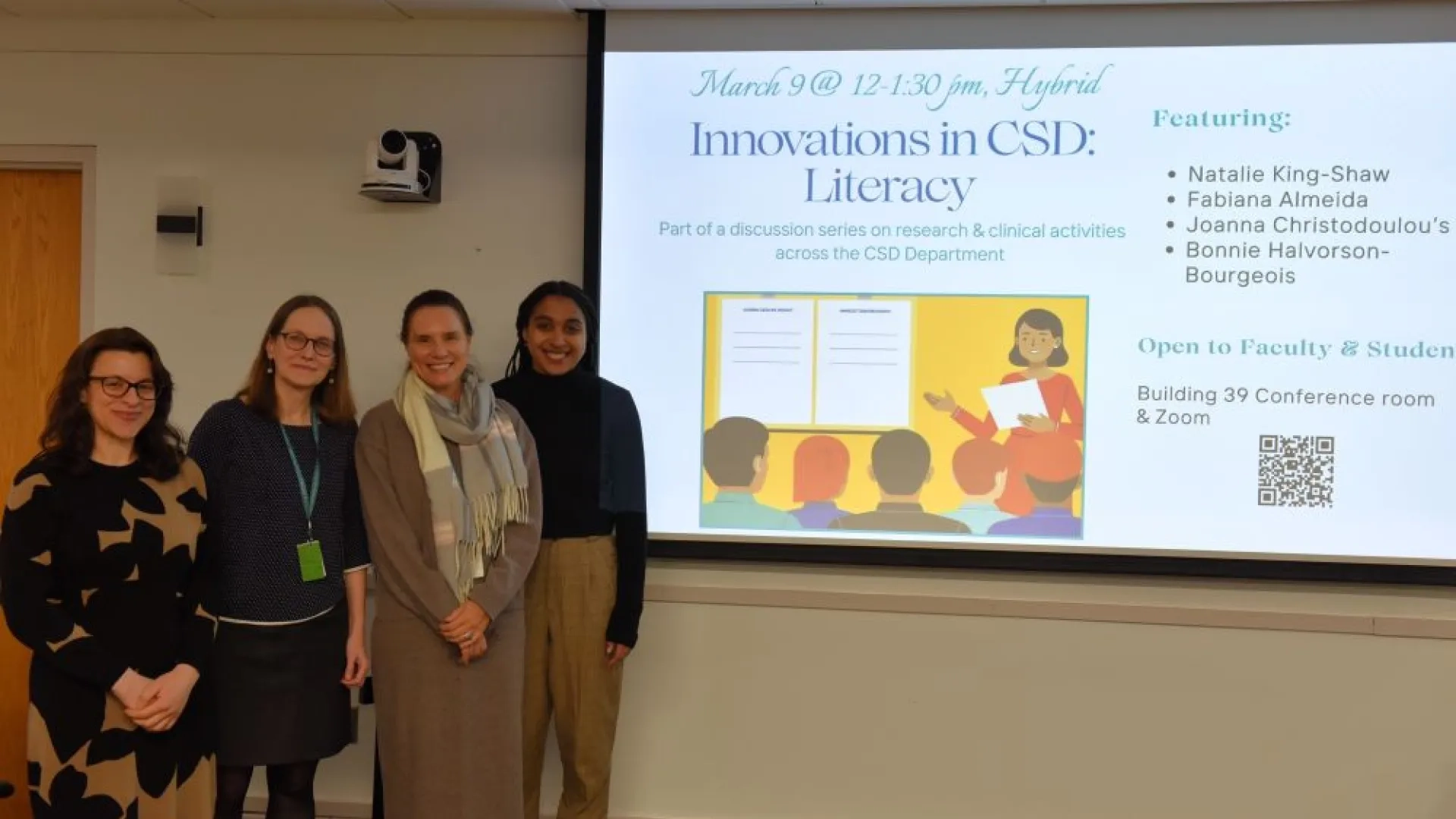 4 women standing left of a screen