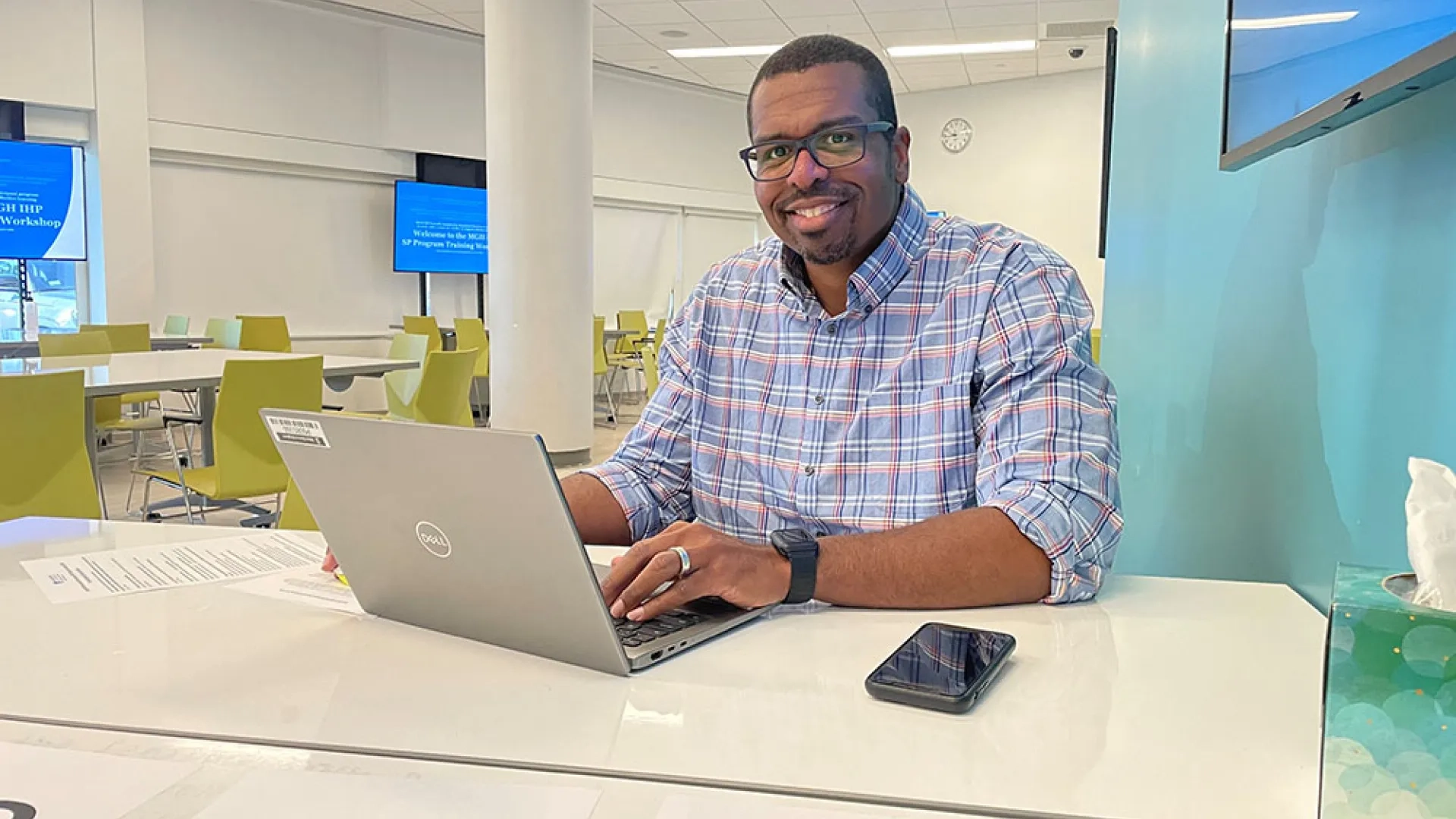 A man sits at a table with a laptop in front of him