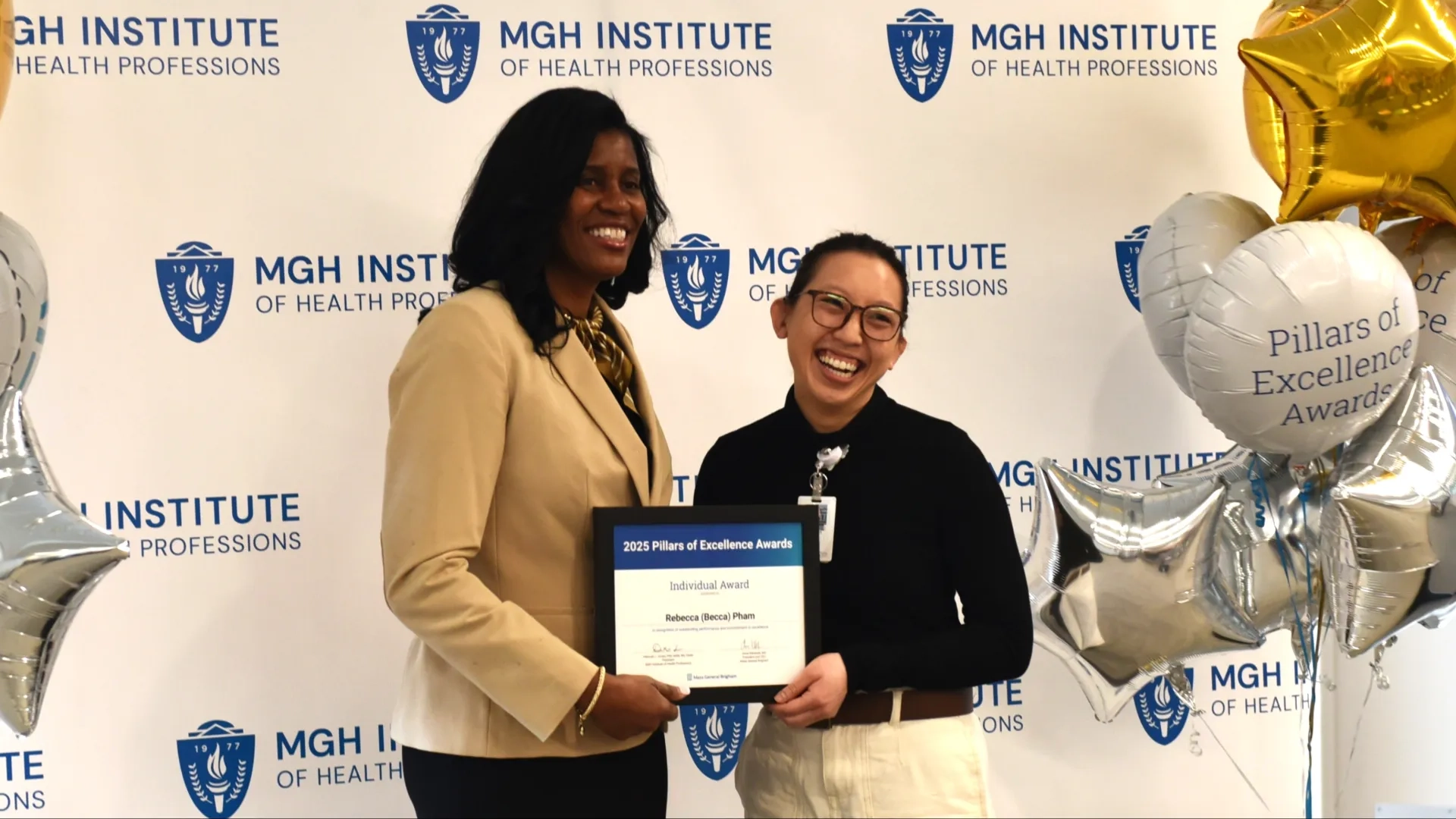 Two people posing for award photo