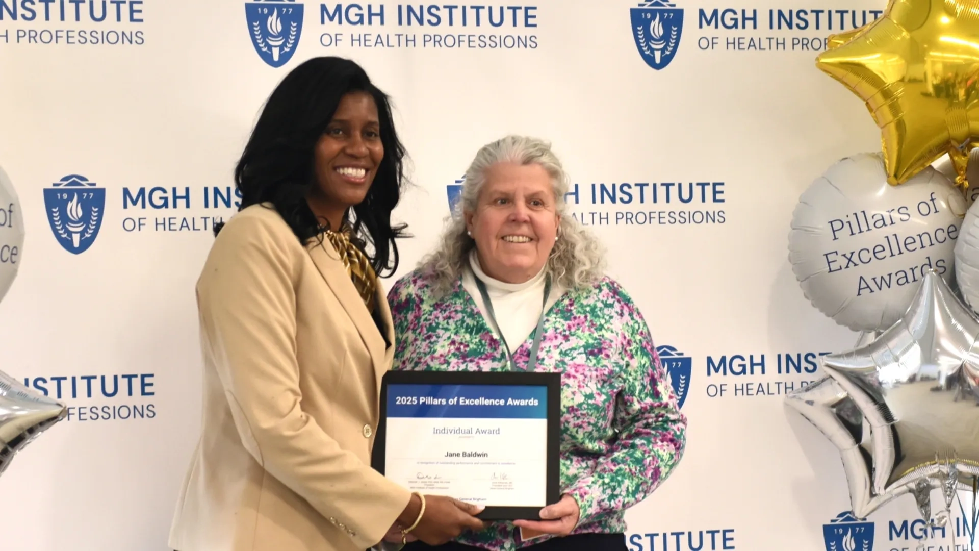 Two people posing for award photo