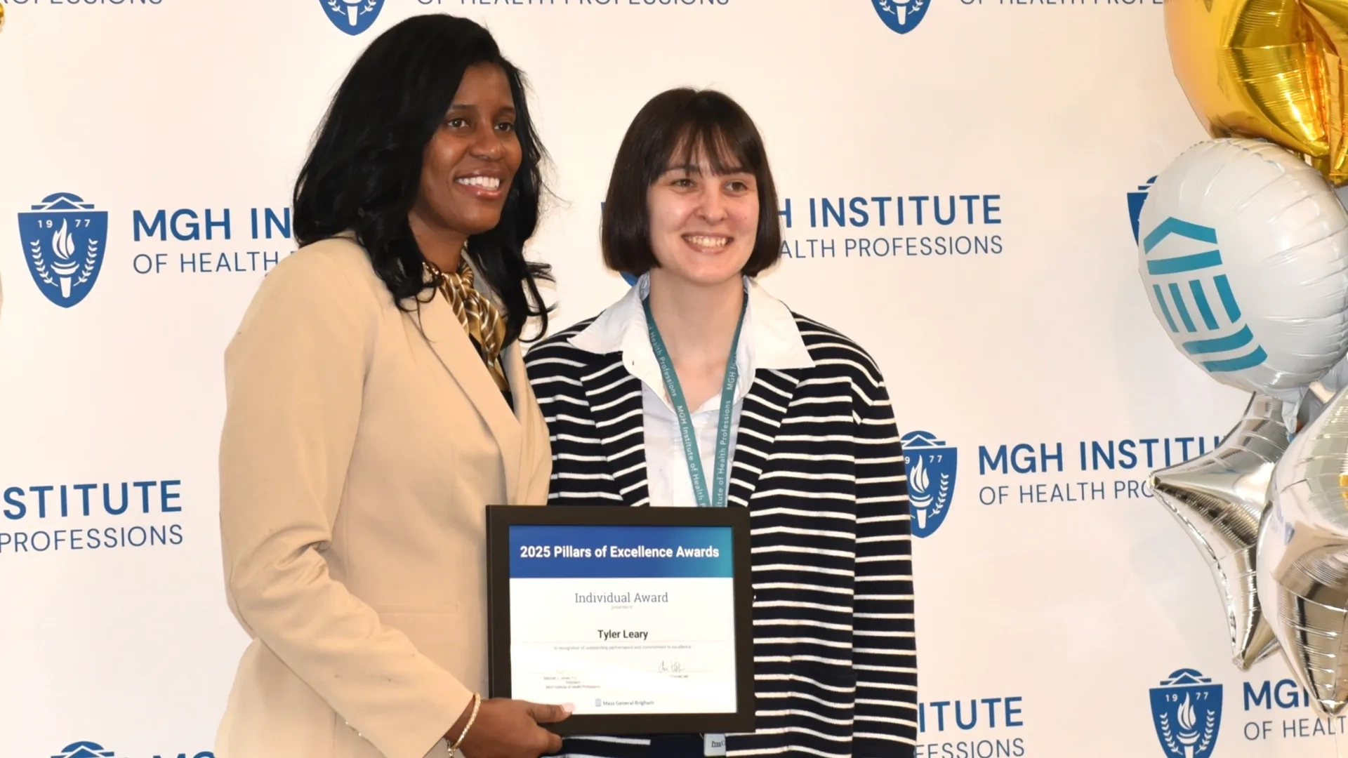 Two people posing for award photo
