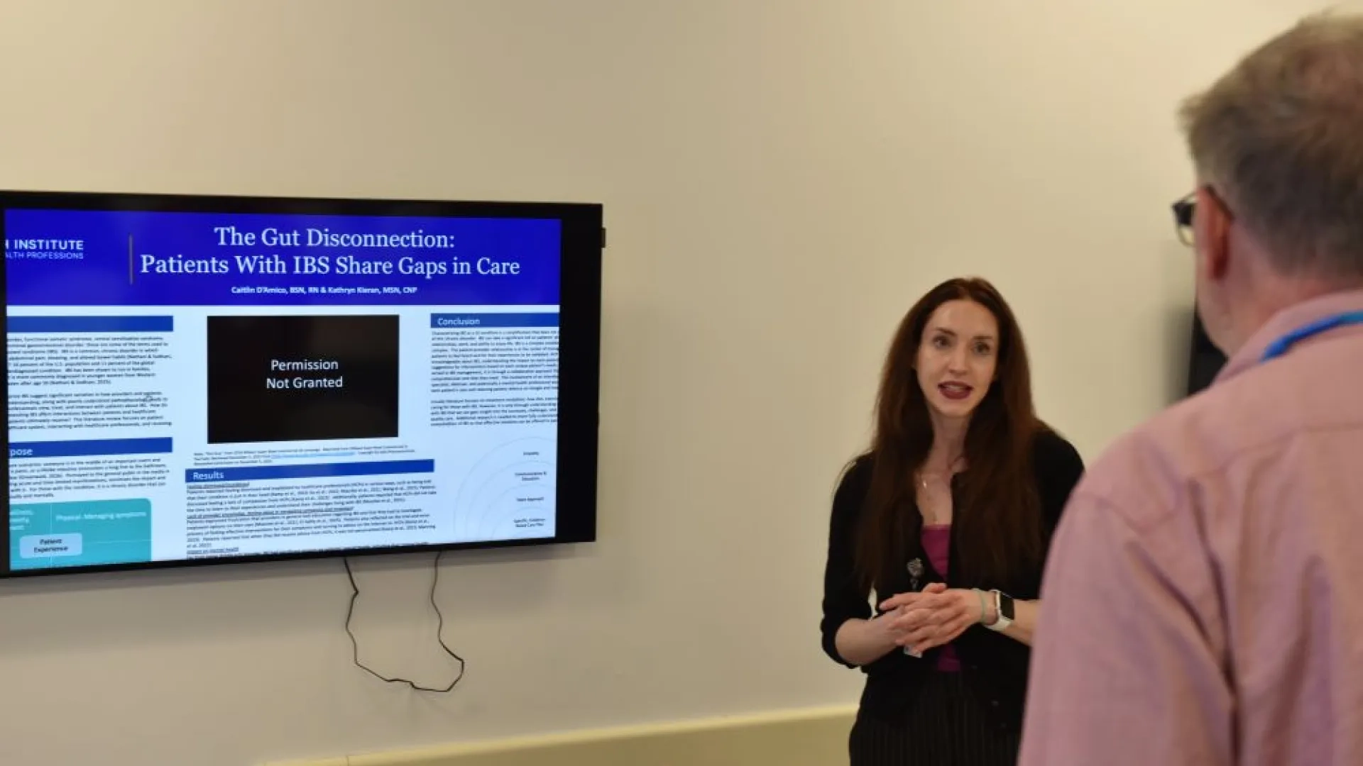 woman talking to a man in front of a screen 