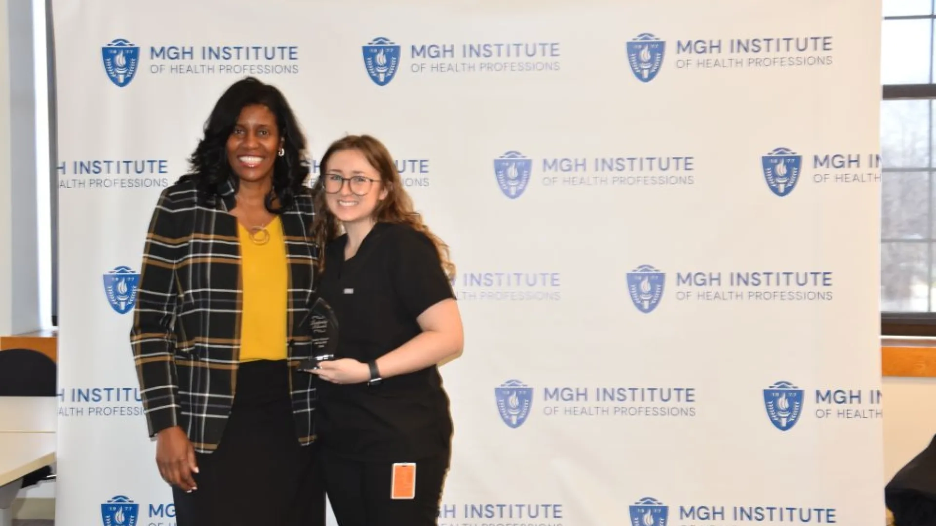 Two people posing for award photo