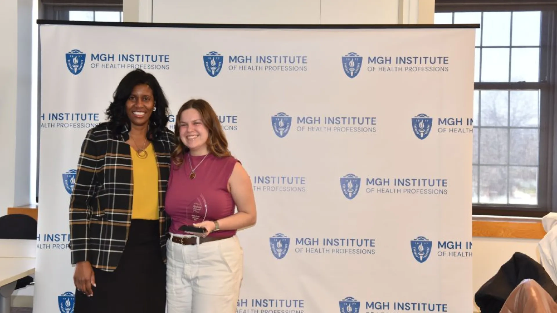 Two women posing with an award