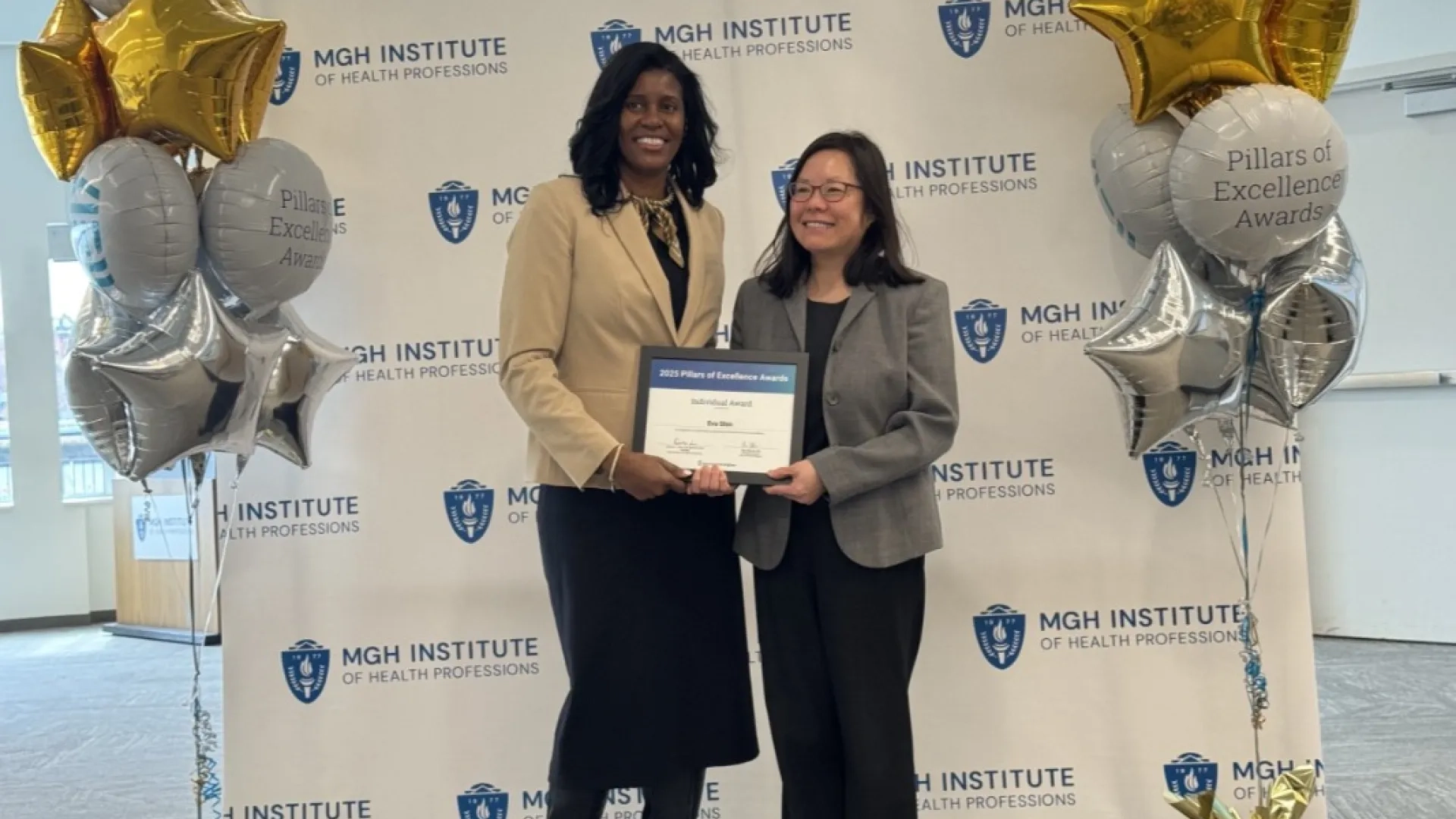 two women standing holding an award