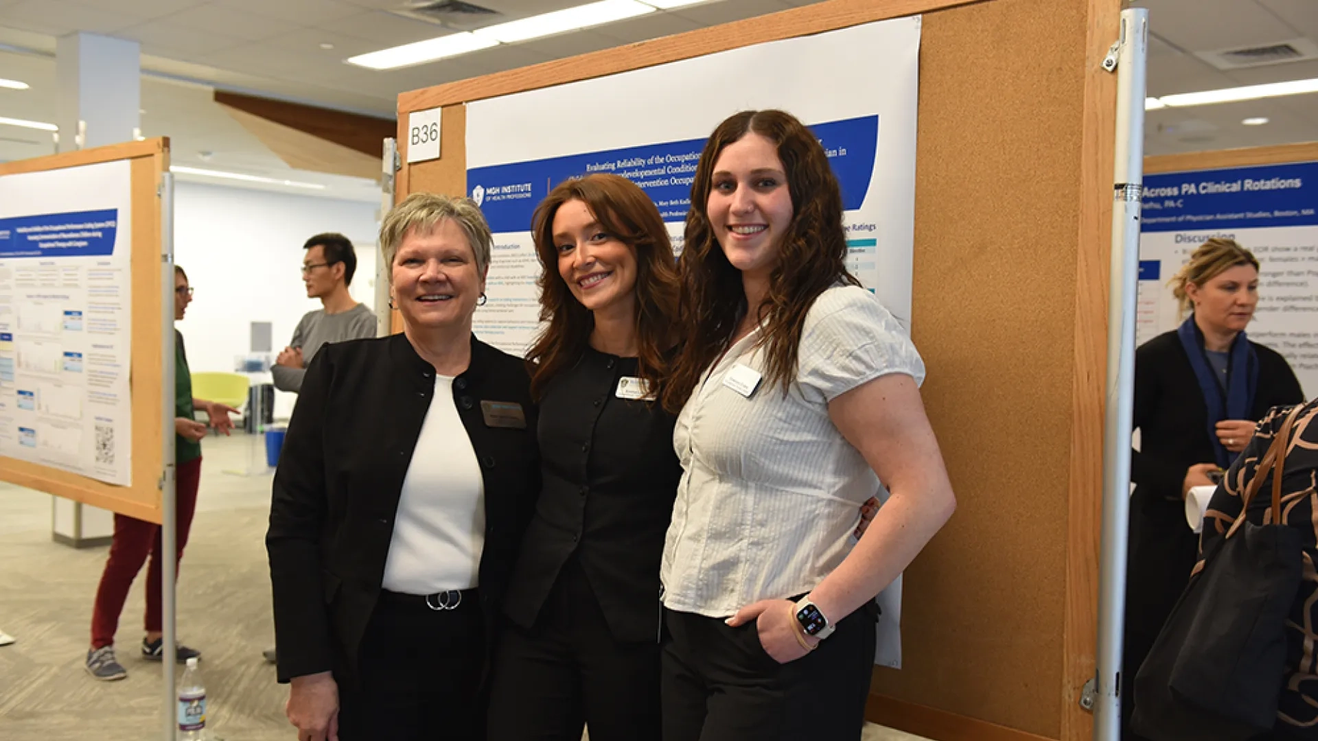 Three women stand near a poster on assessing communication of neurodiverse children during occupational therapy with caregivers